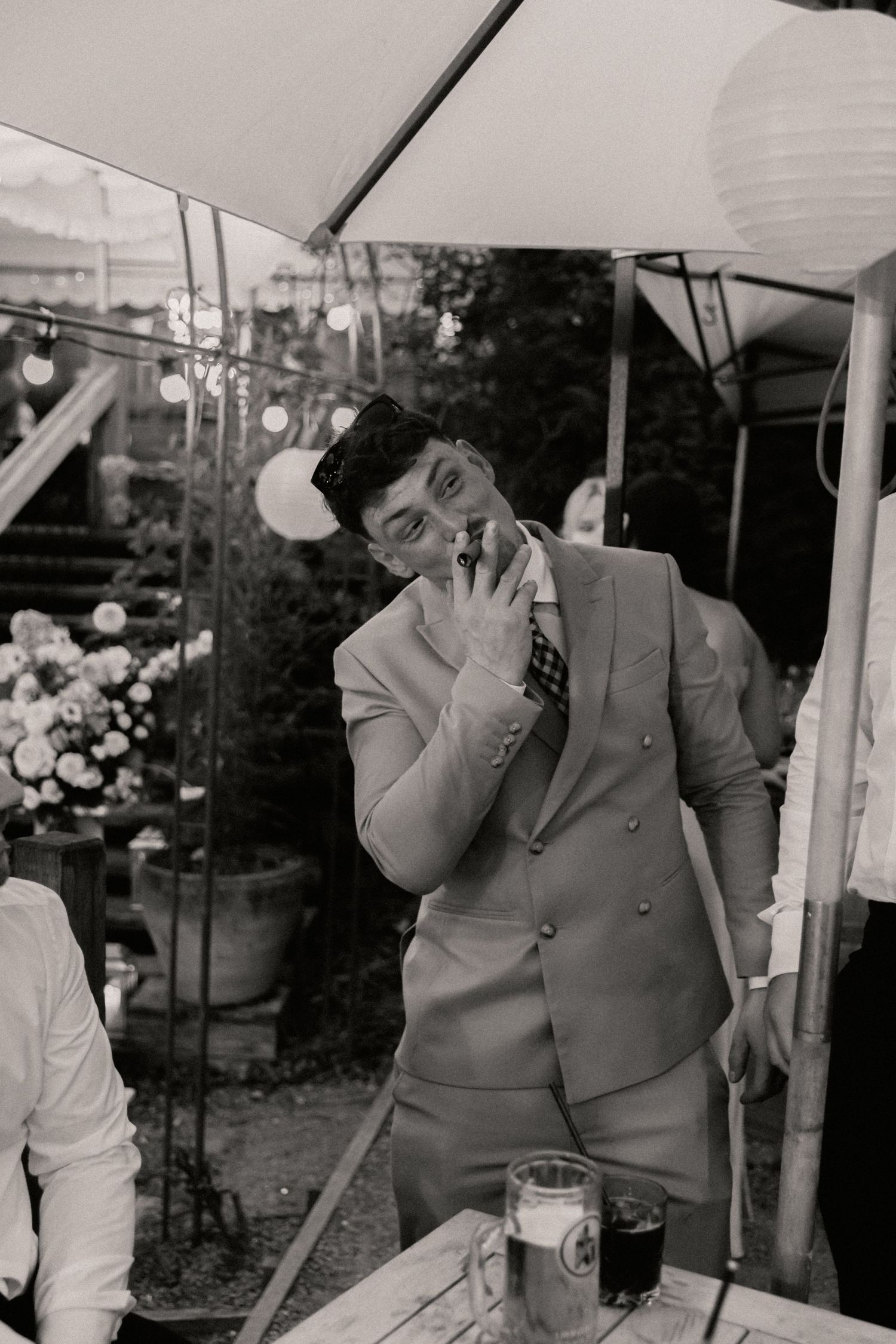 Groomsmen smoking cigar during evening of wedding outside Roebuck Inn
