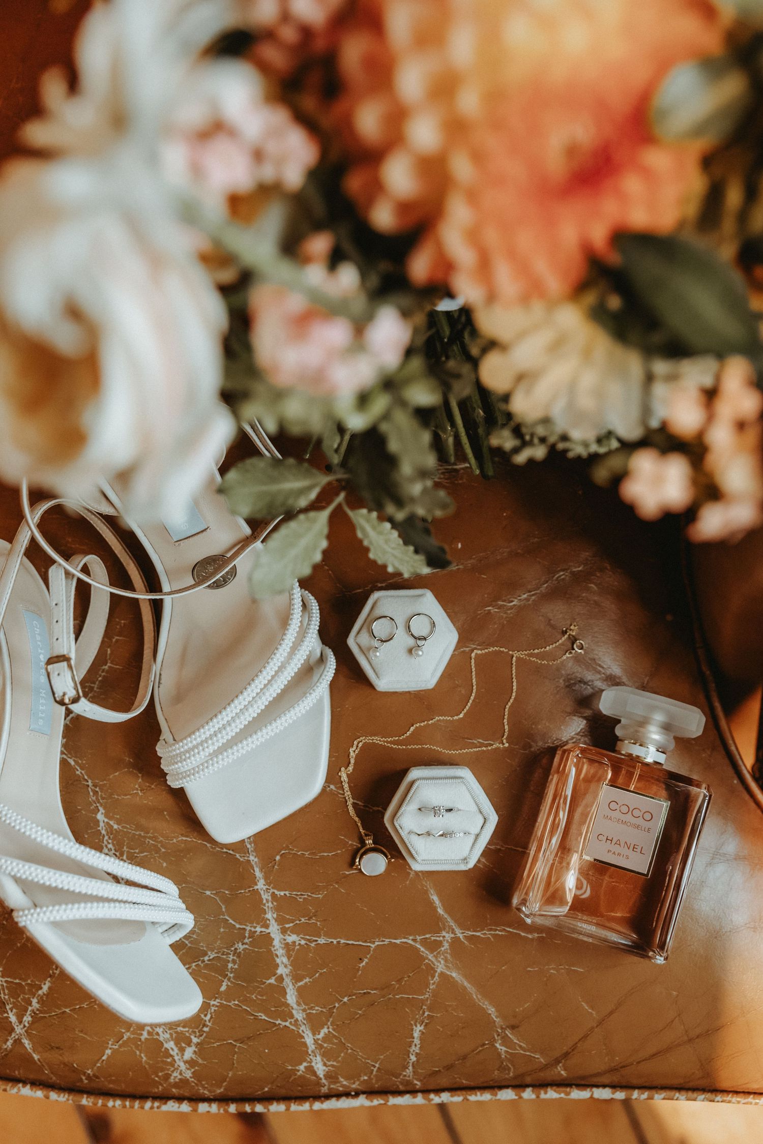 Details from bridal prep of perfume, bridal shoes, jewellery and bouquet