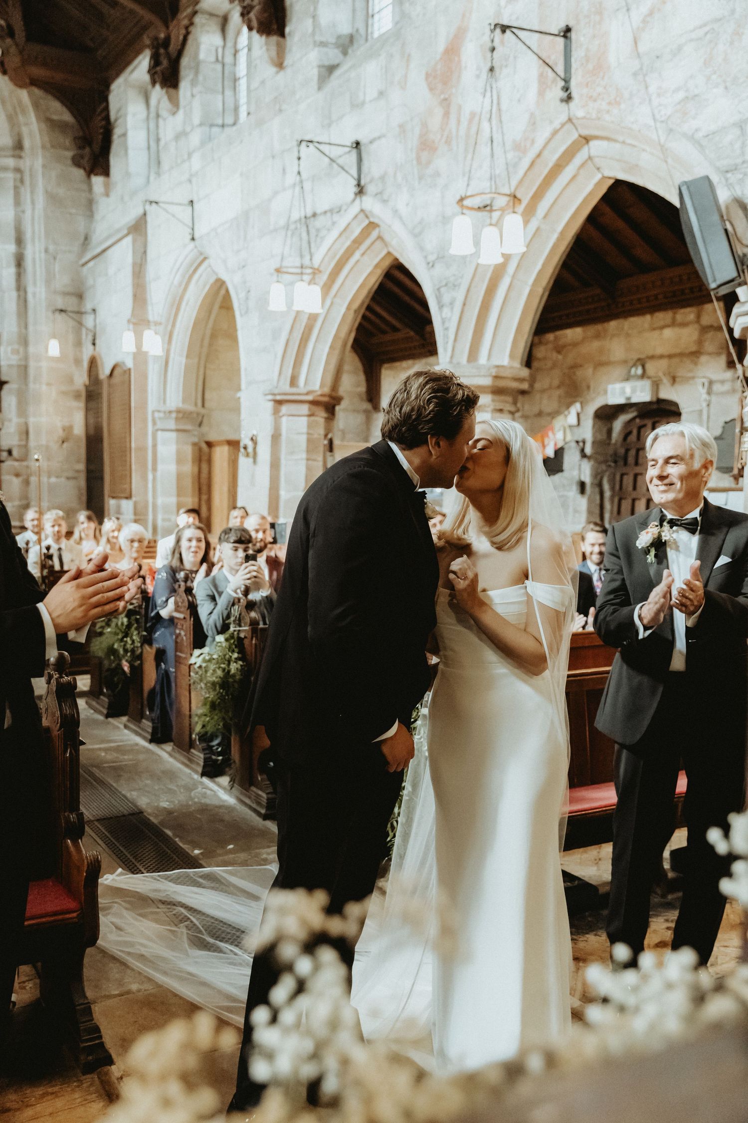 Bride and groom having first kiss during wedding ceremony St Wilfrids