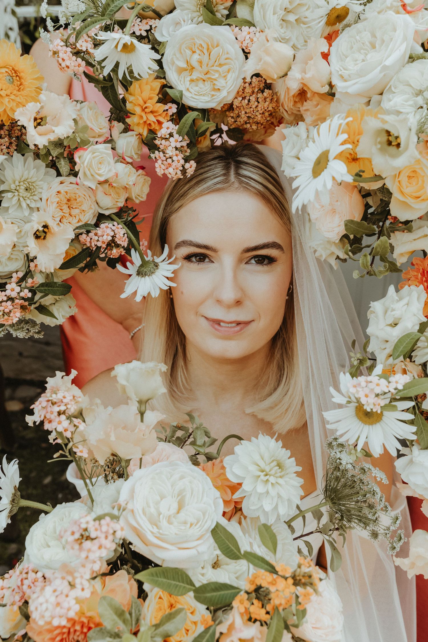 Brides face with bridesmaids bouquets framing the edges