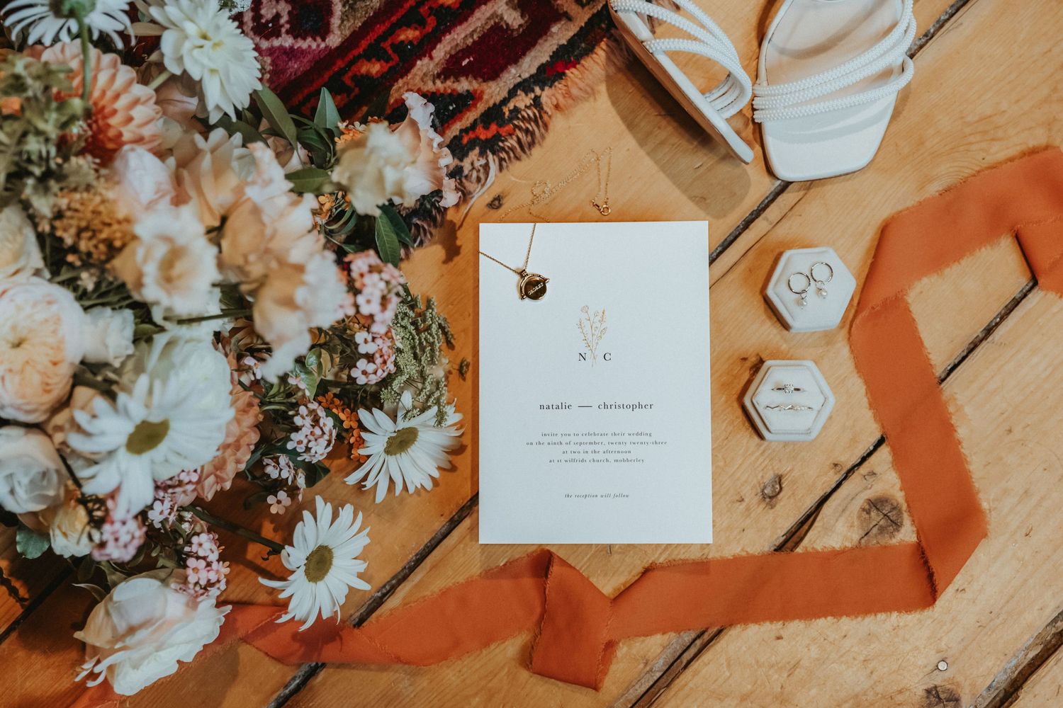 Wedding invitation flat lay with bridal bouquet and jewellery