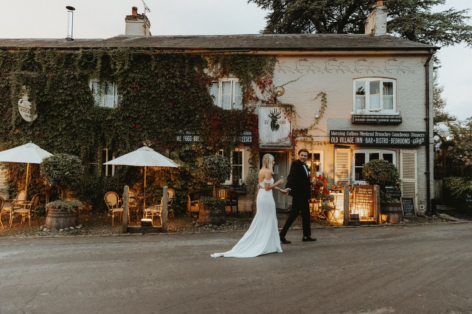 Bride and groom walking in front of their wedding venue in Cheshire. The Roebuck Inn