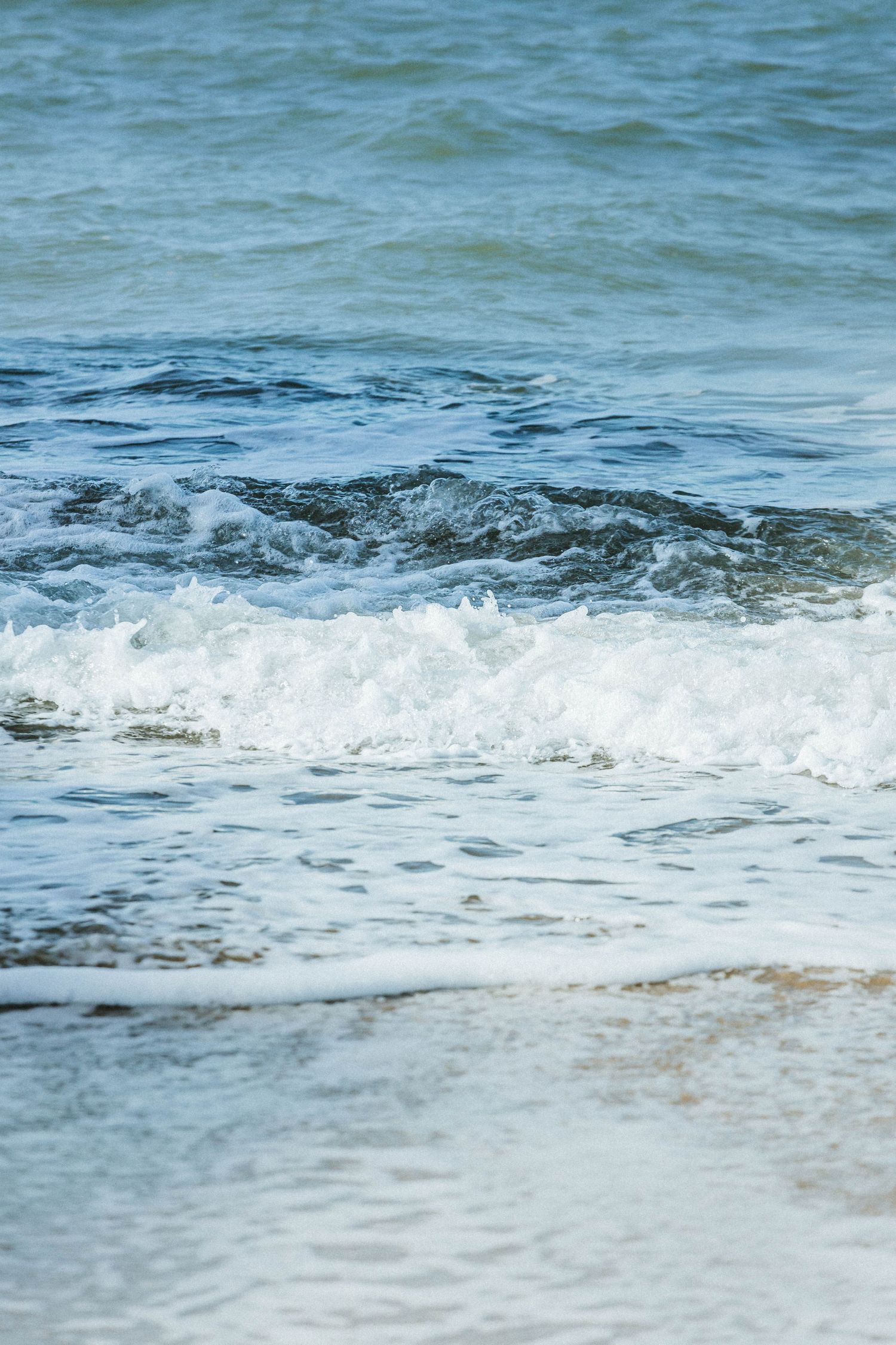 Waves gently lapping up along the shore in Tenby South Wales