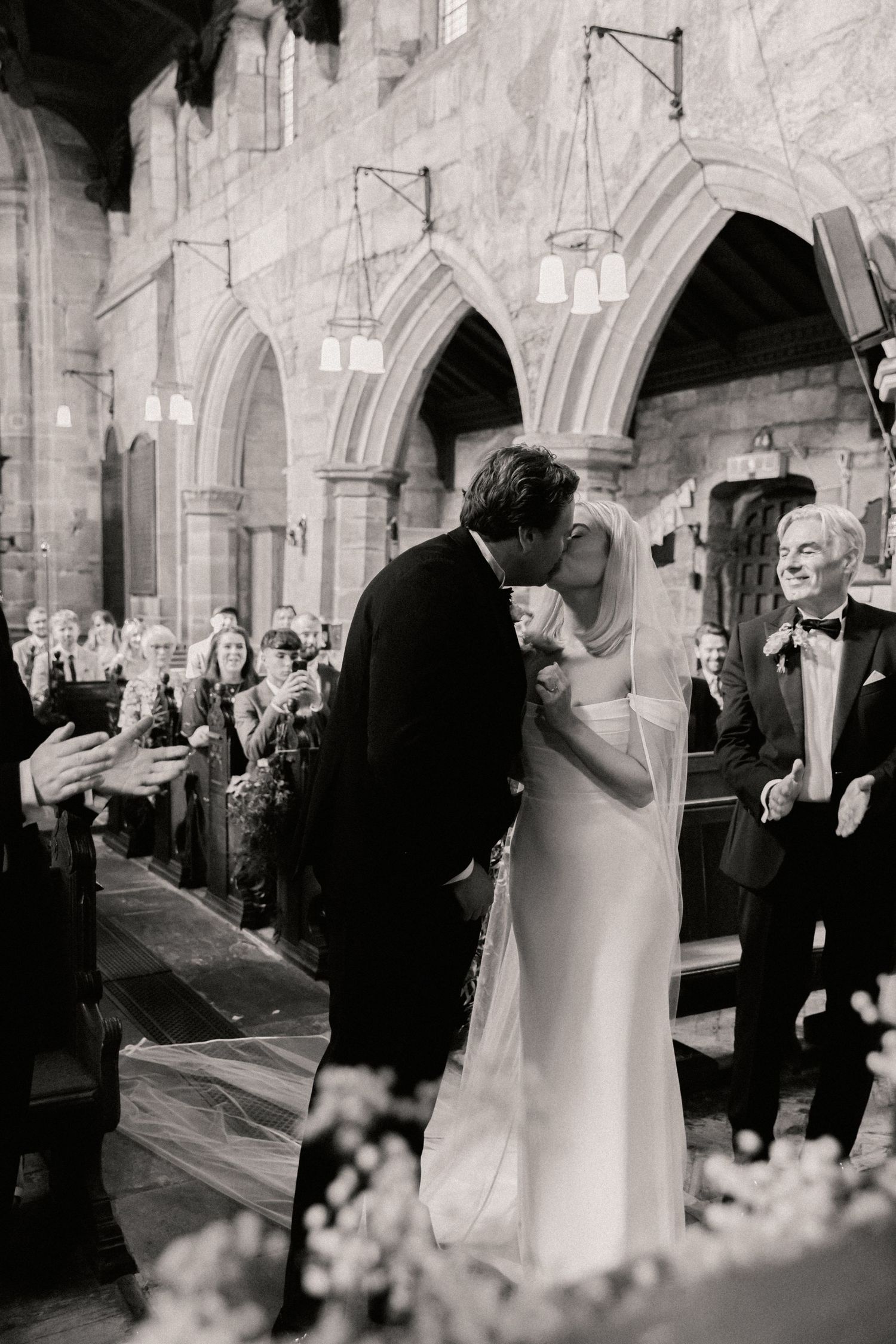 Bride and groom having their first kiss at St Wilfrids church in Mobberley