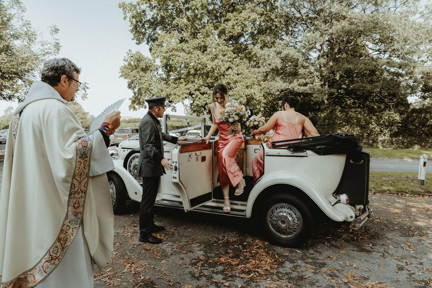 Wedding car pulling up outside of St Wilfrids church in Mobberley with bridesmaids ready to get out