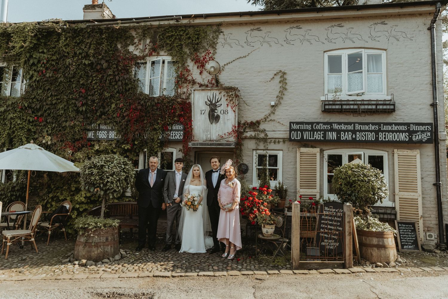 Bride and groom standing with grooms family outside the venue in Cheshire
