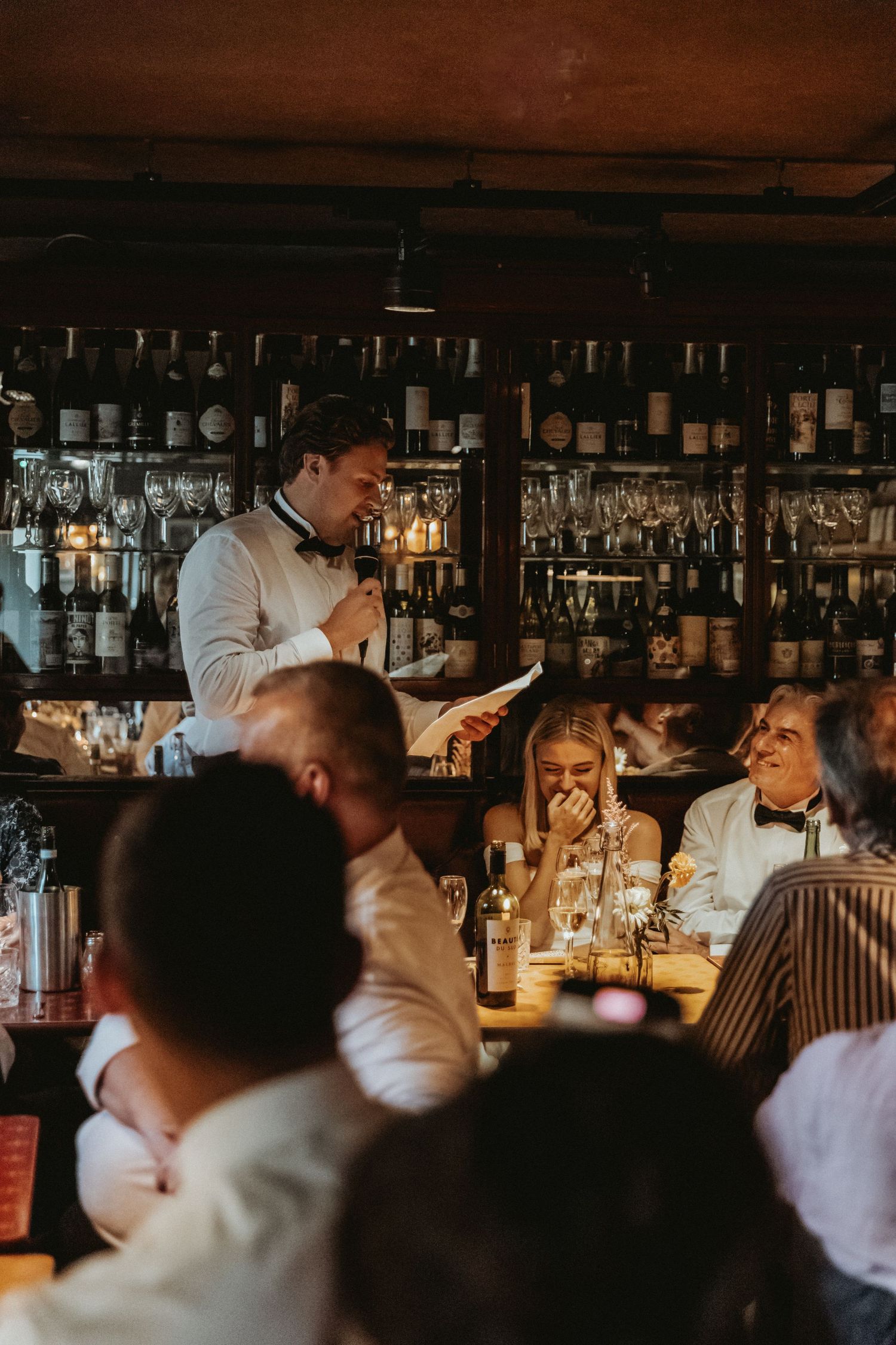 Groom looking at bride at top table of wedding reading speech