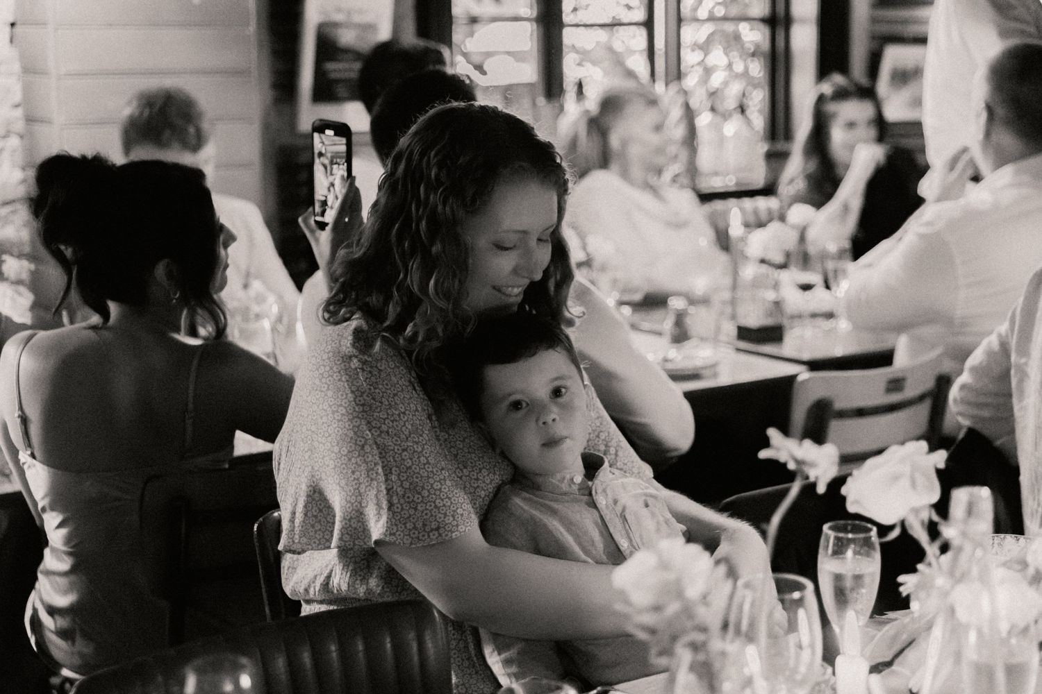 Mother cuddling her child during speeches at wedding