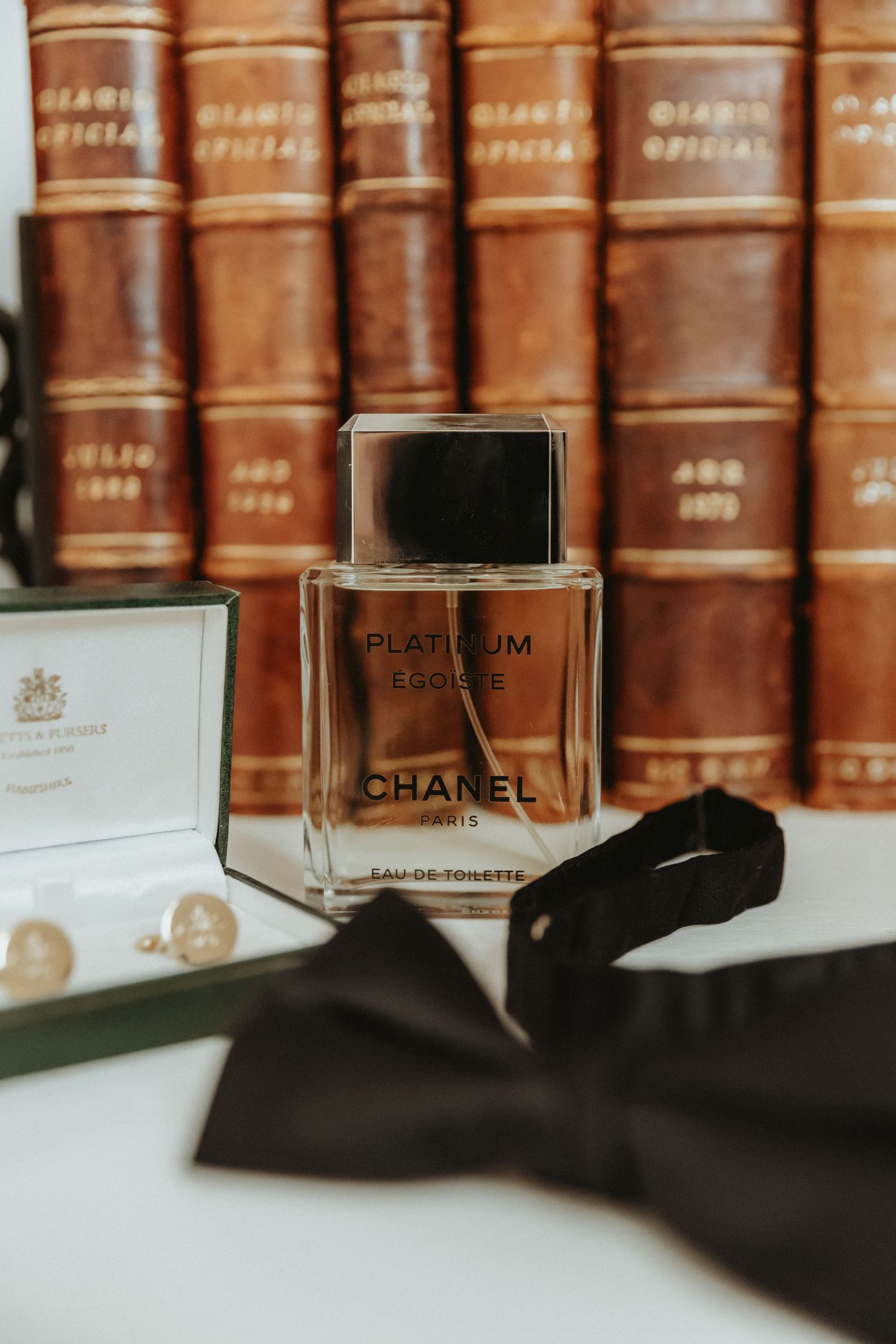 Grooms fragrance with cufflinks and bow tie during groom prep at an airbnb