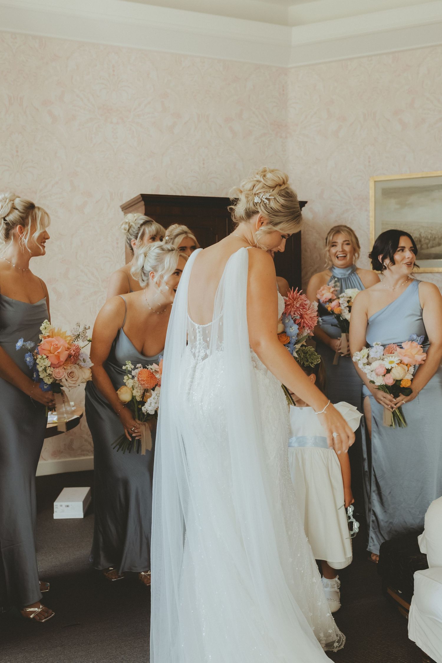 Bride with her bridal party in prep room at Askham Hall before her outdoor ceremony