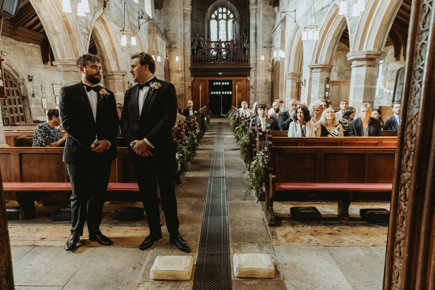 Groom and best man standing at front of church waiting for brides entrance