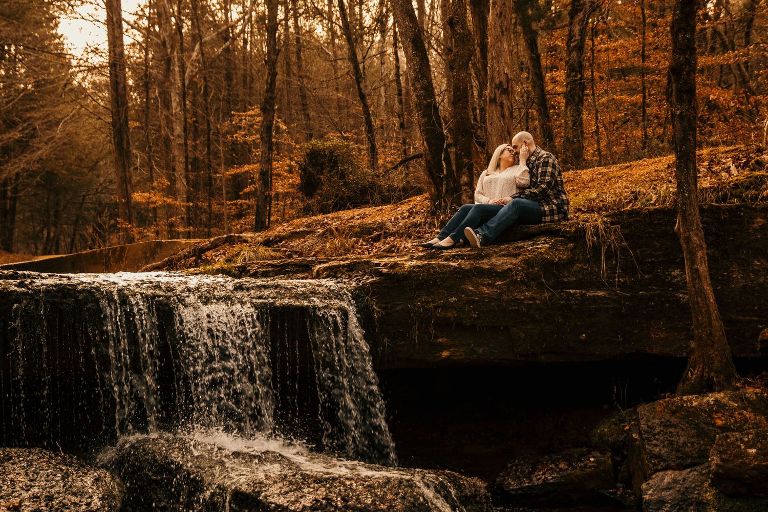 coy and girl sitting above a waterfall leaning into each other