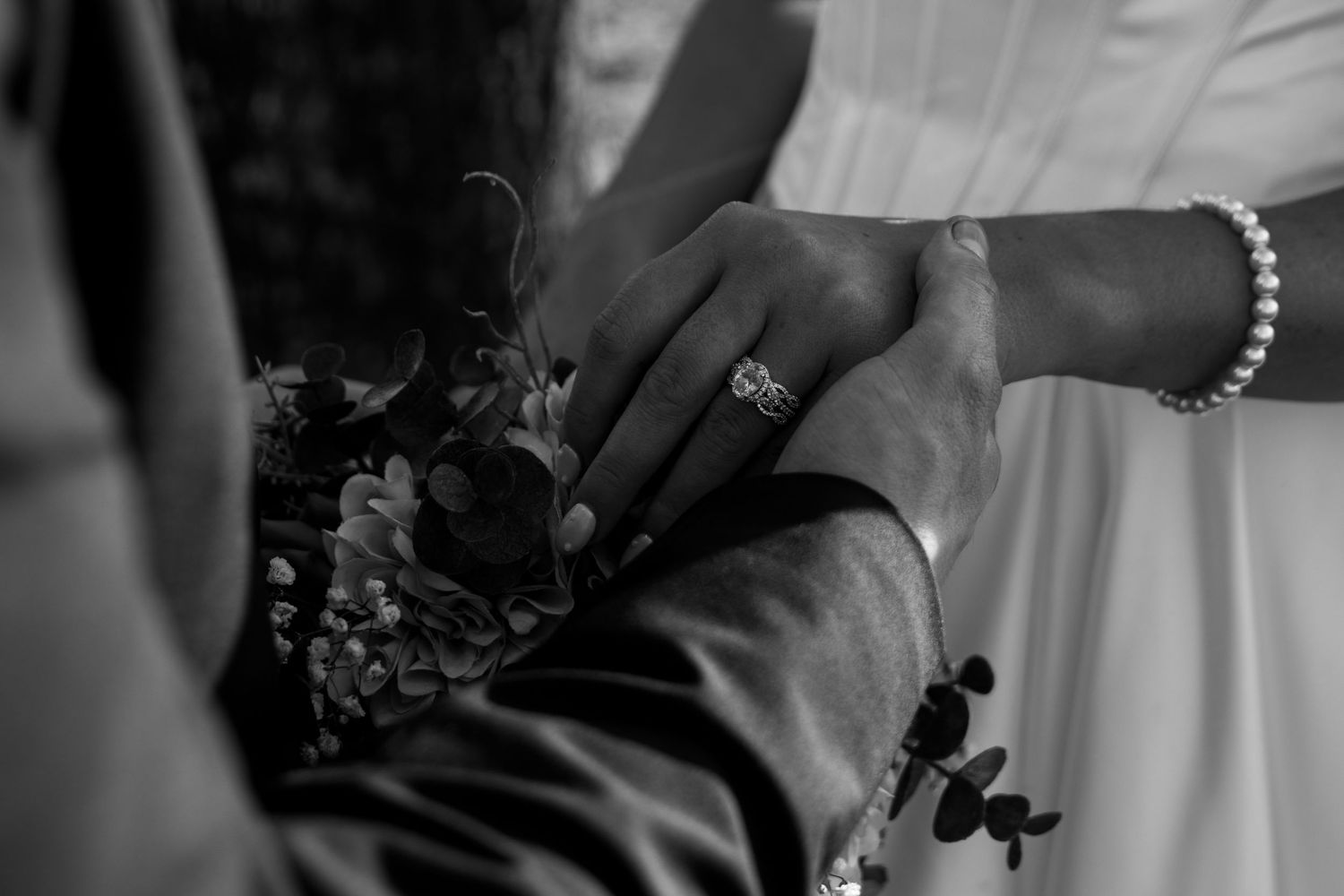 detail shot of bride and groom holding hands