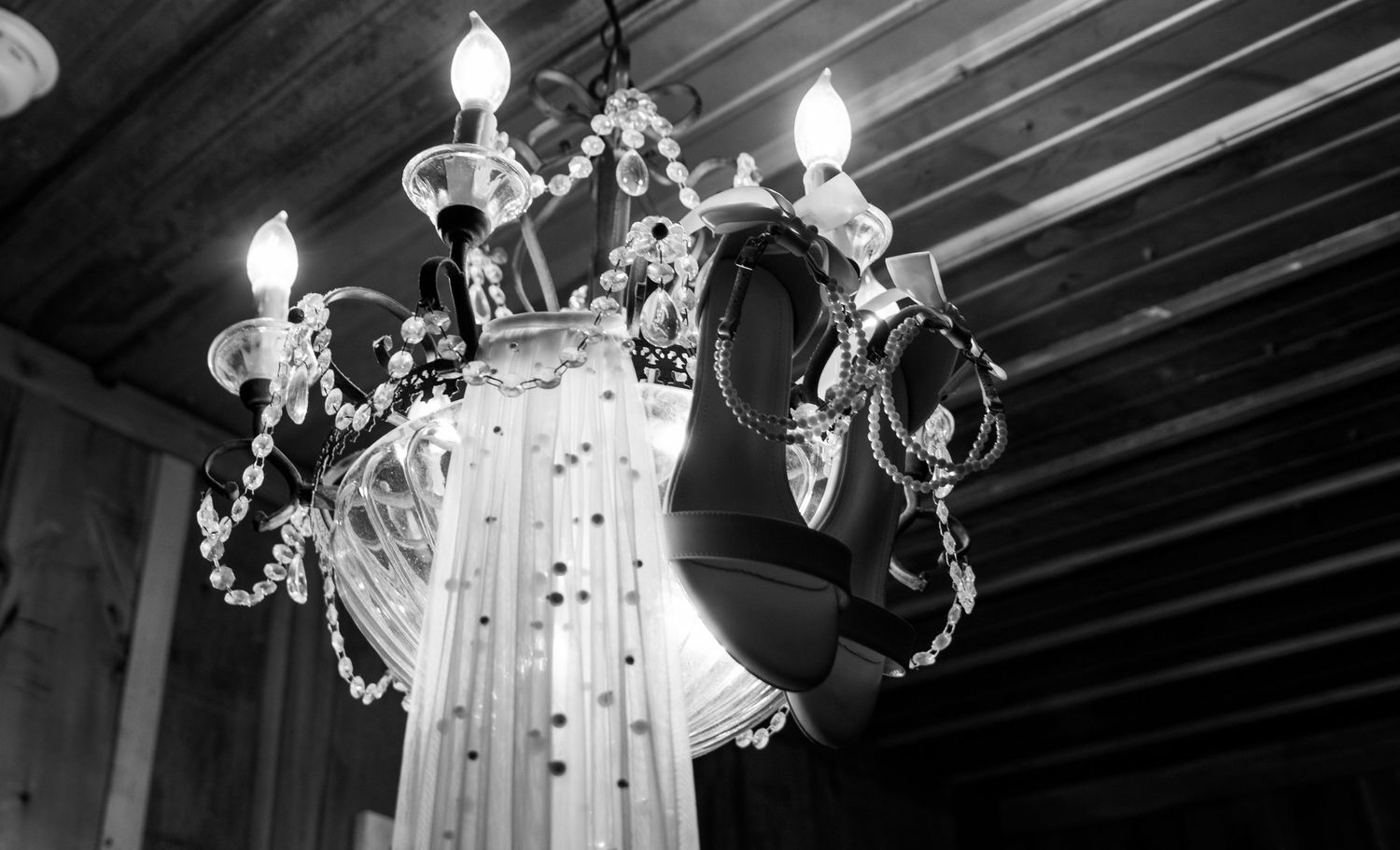 brides heels hanging from chandelier