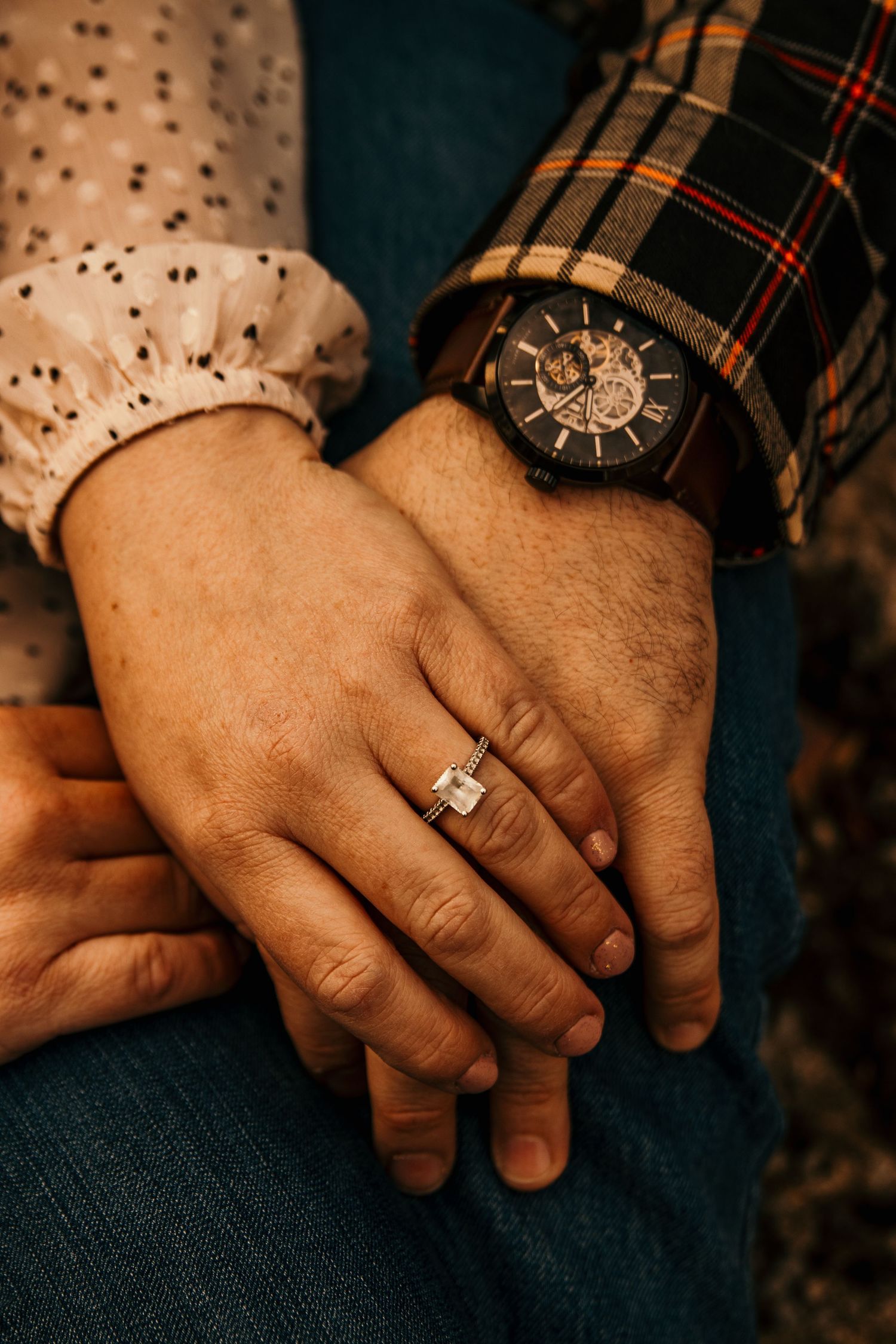 detail shot of brides ring and grooms watch while holding hands