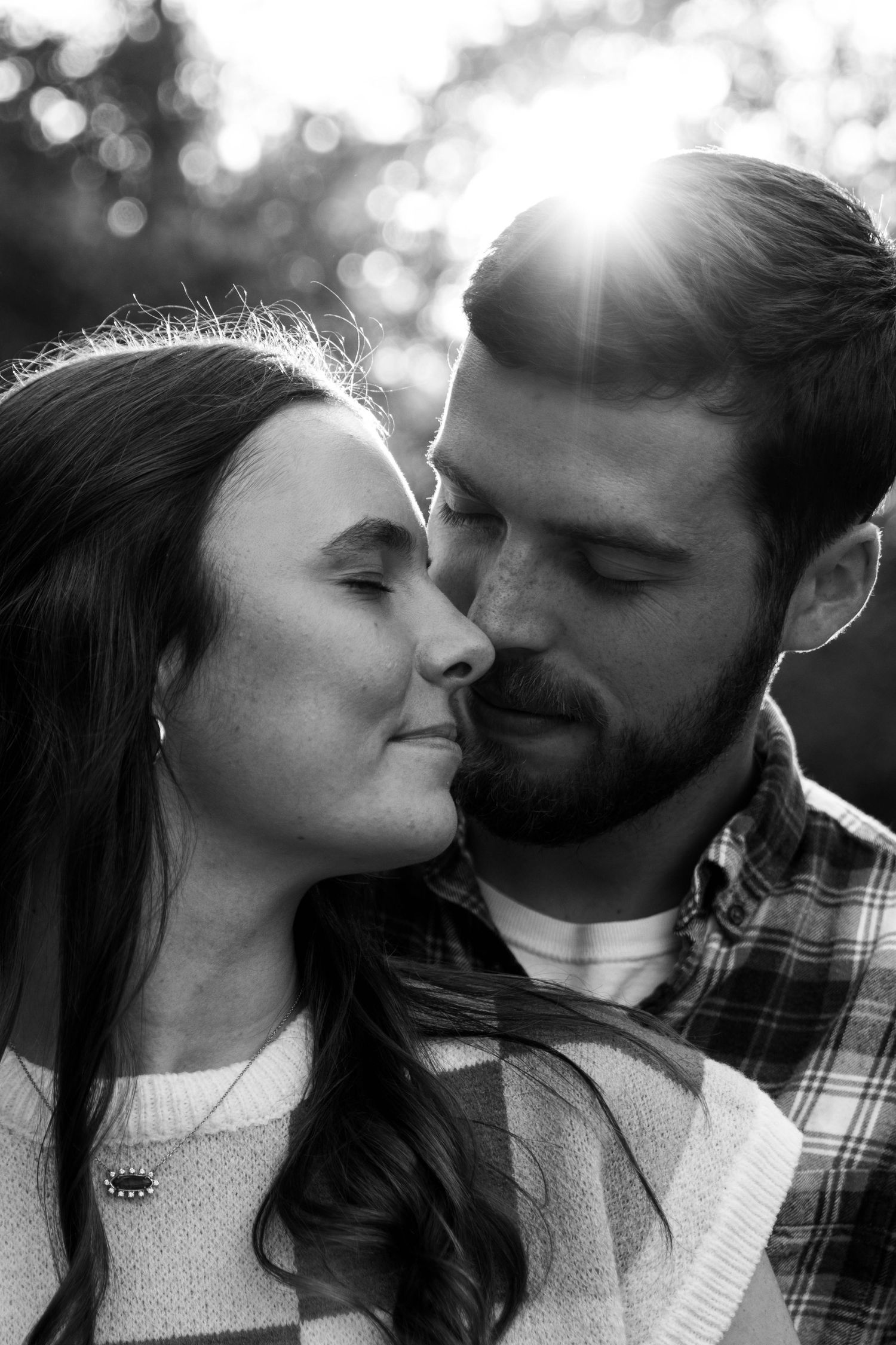 boy and girl nose to nose with sun rays peeking through