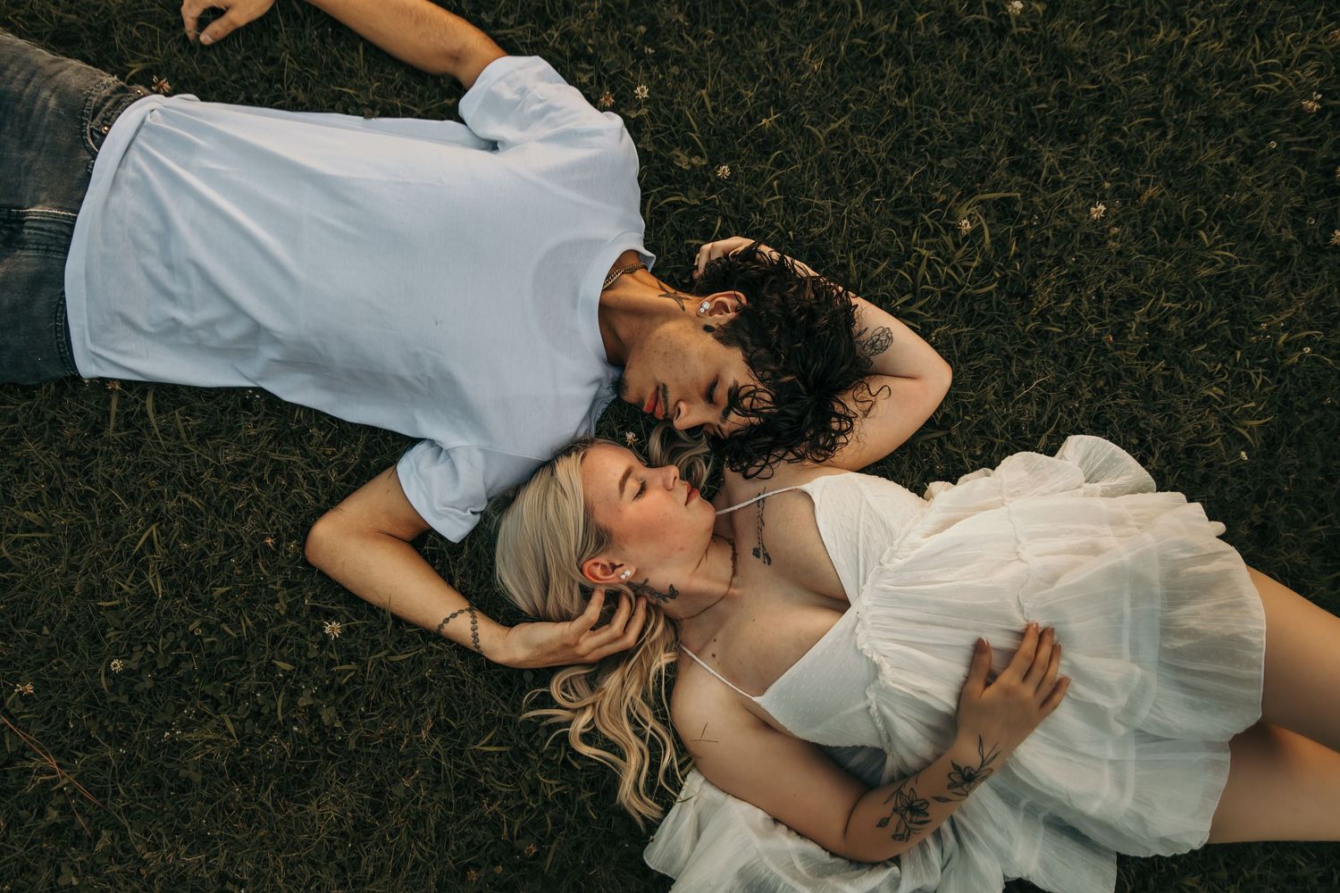 guy and girl laying opposite directions on the ground gazing at each other