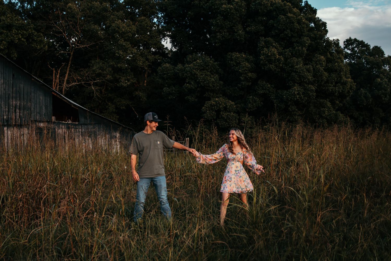boy and girl holding hands roaming through field