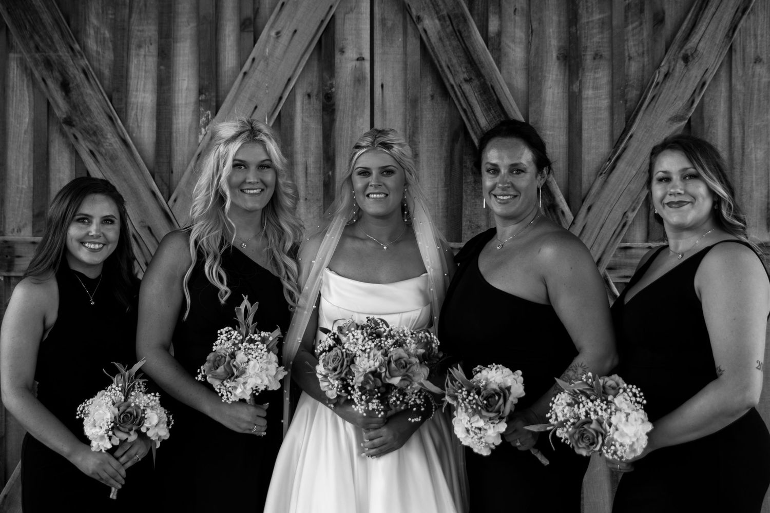 bride and bridesmaid portrait in front of rustic barn