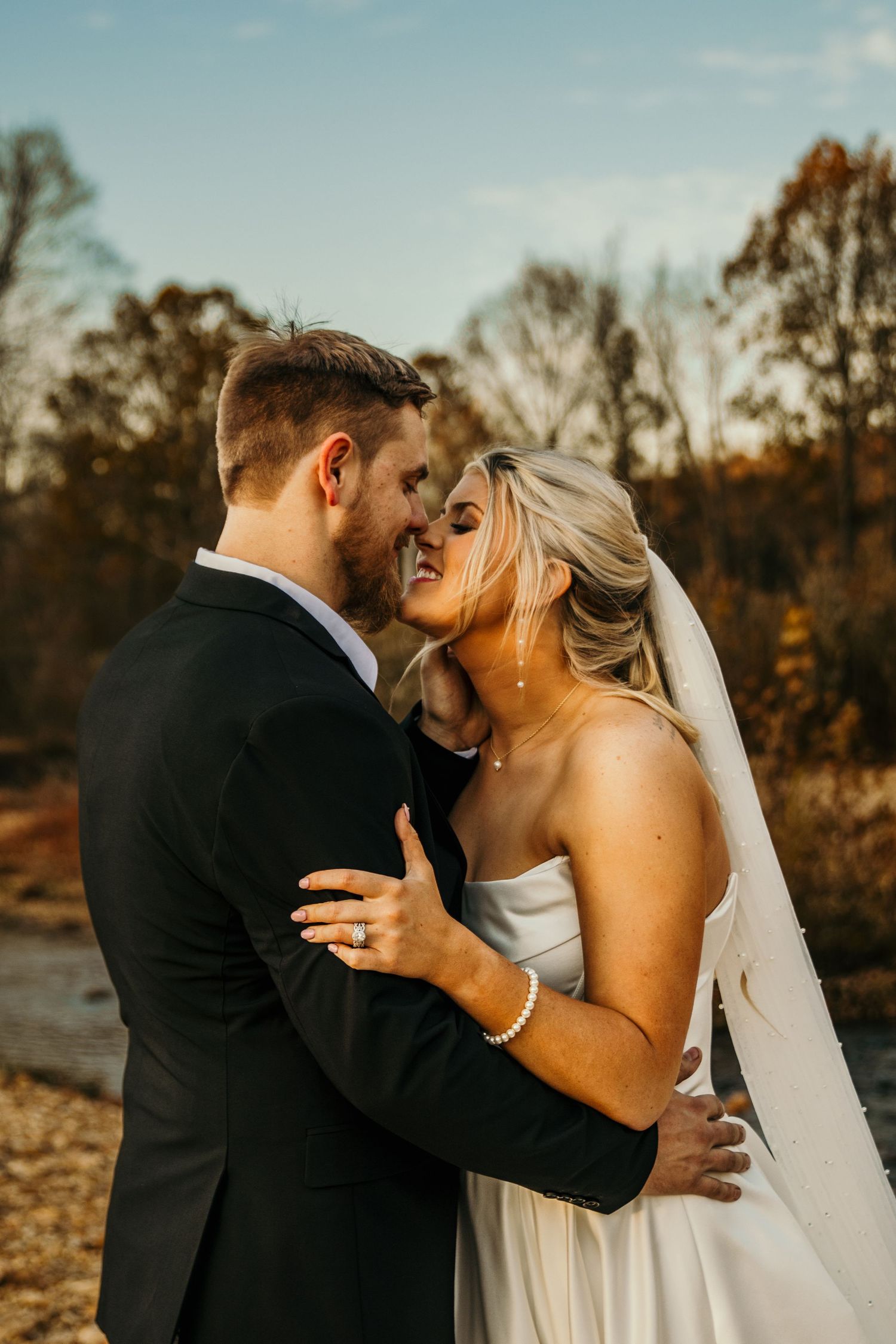 bride and groom hugging closely while touching nose to nose