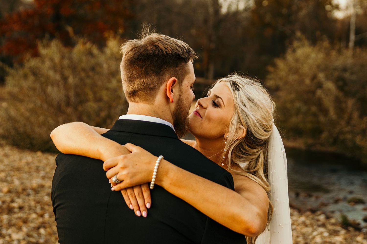 bride staring at groom with arms wrapped around his neck