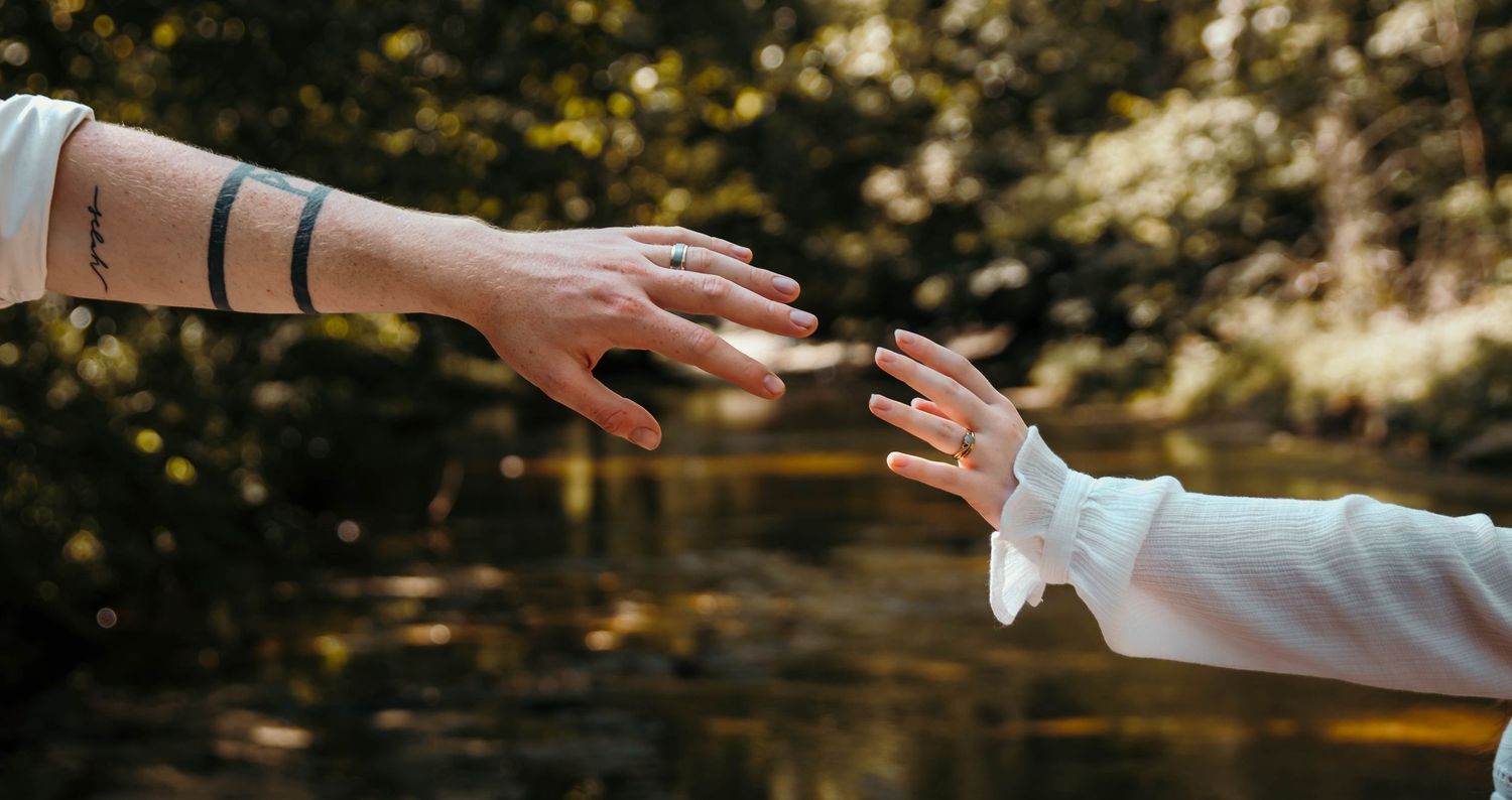 Boy and girl reaching out to grab the other's hand and feeling the connection grow stronger the closer they get.
