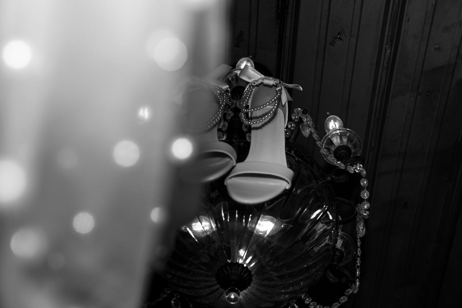 detail shot of brides heels and veil hanging from chandelier