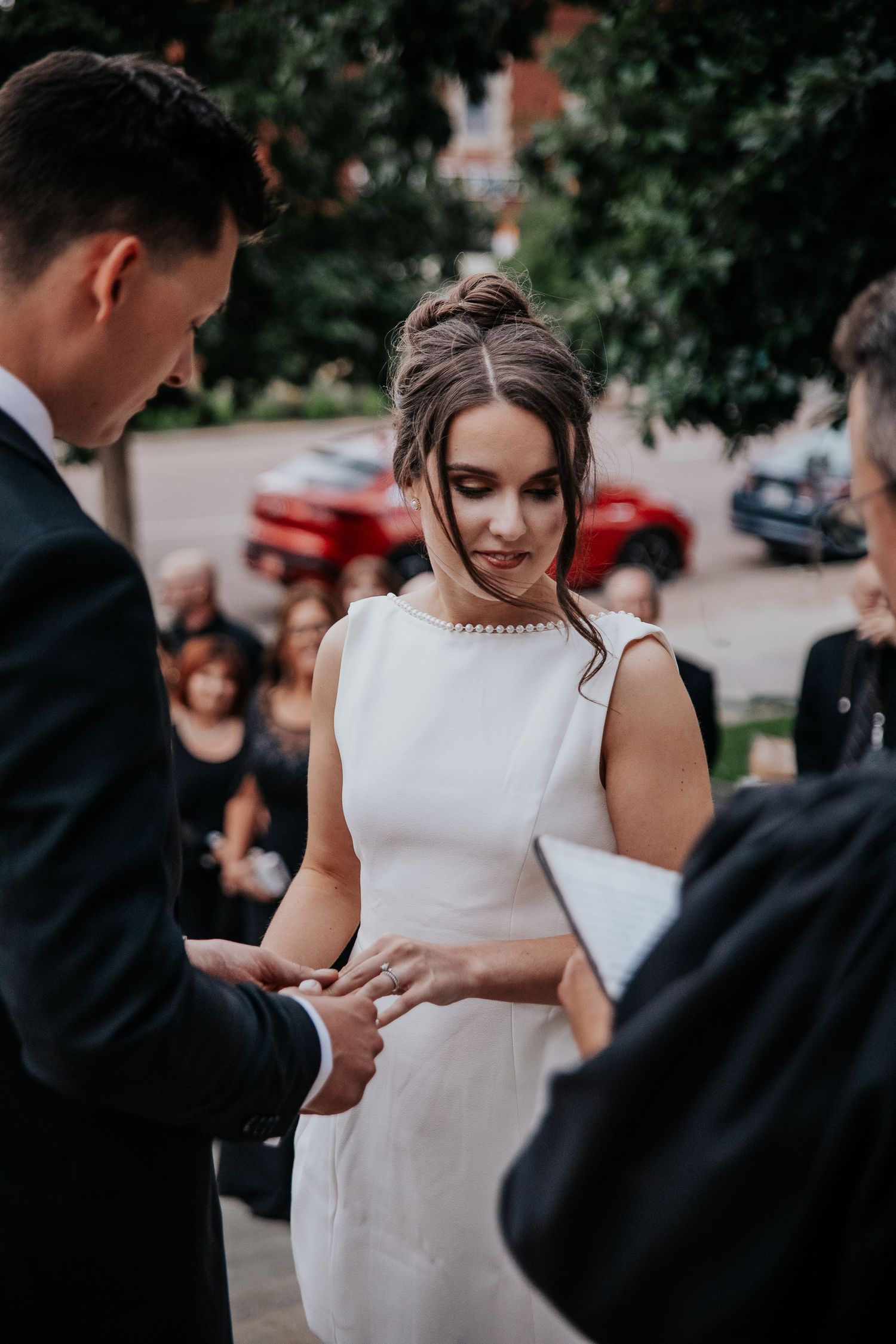 A couple exchanging rings during an intimate outdoor wedding ceremony.