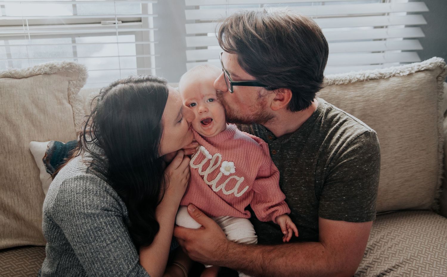 Family shares tender moment together on couch.