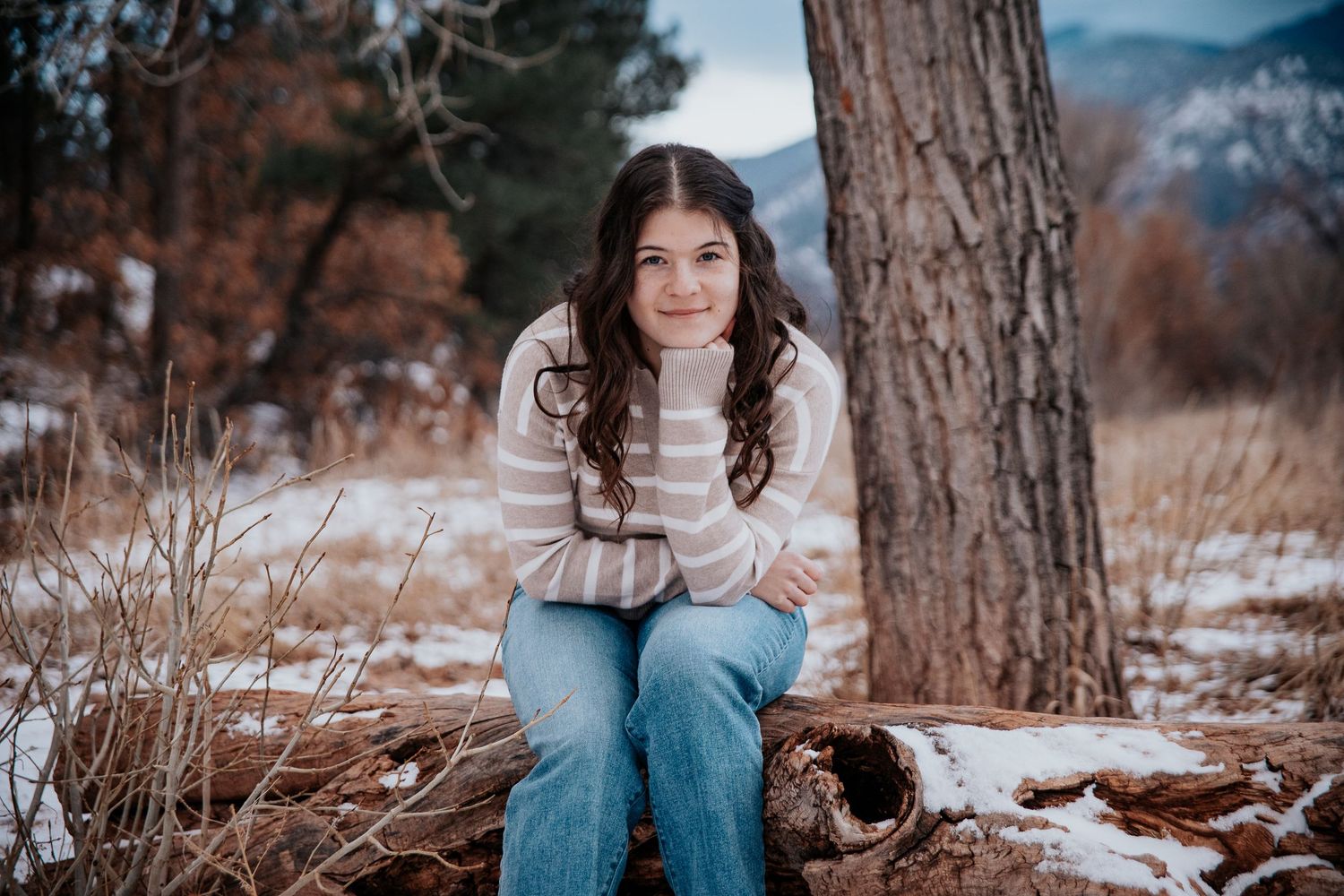 Portrait session near pine trees with mountains visible in the distance.
