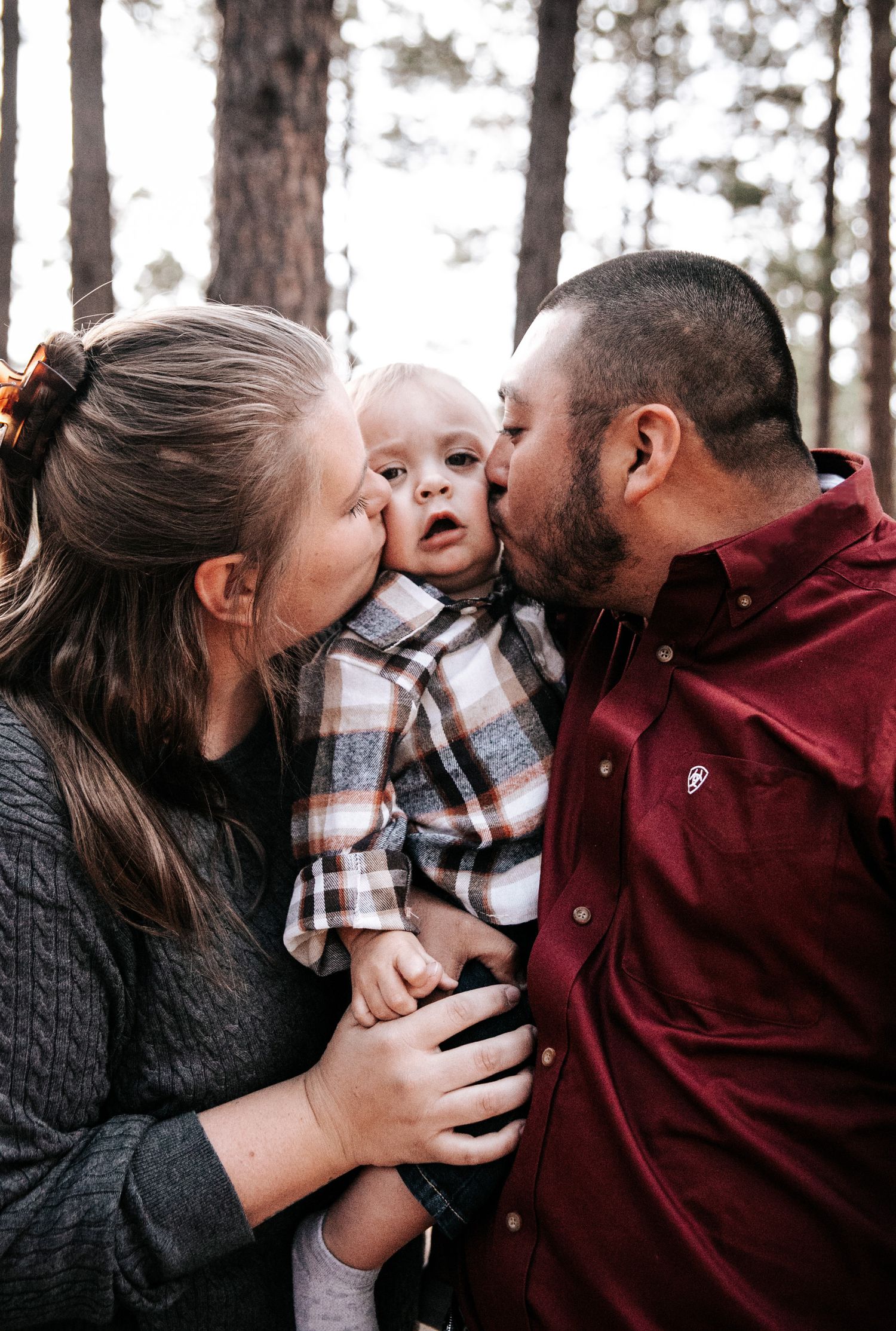 A sweet and intimate moment captured in a snowy forest setting.