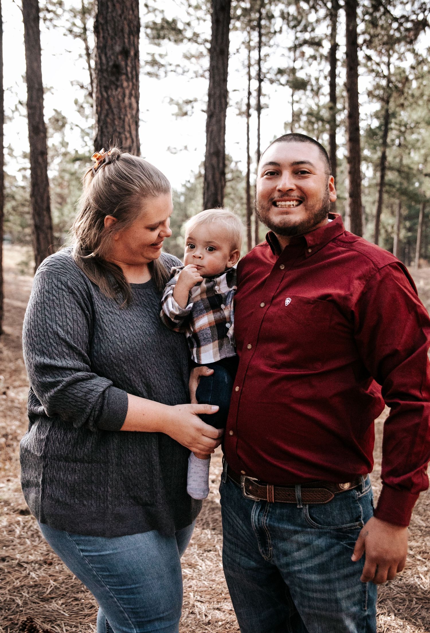 Family sharing joyful moments together in casual outdoor forest photoshoot.