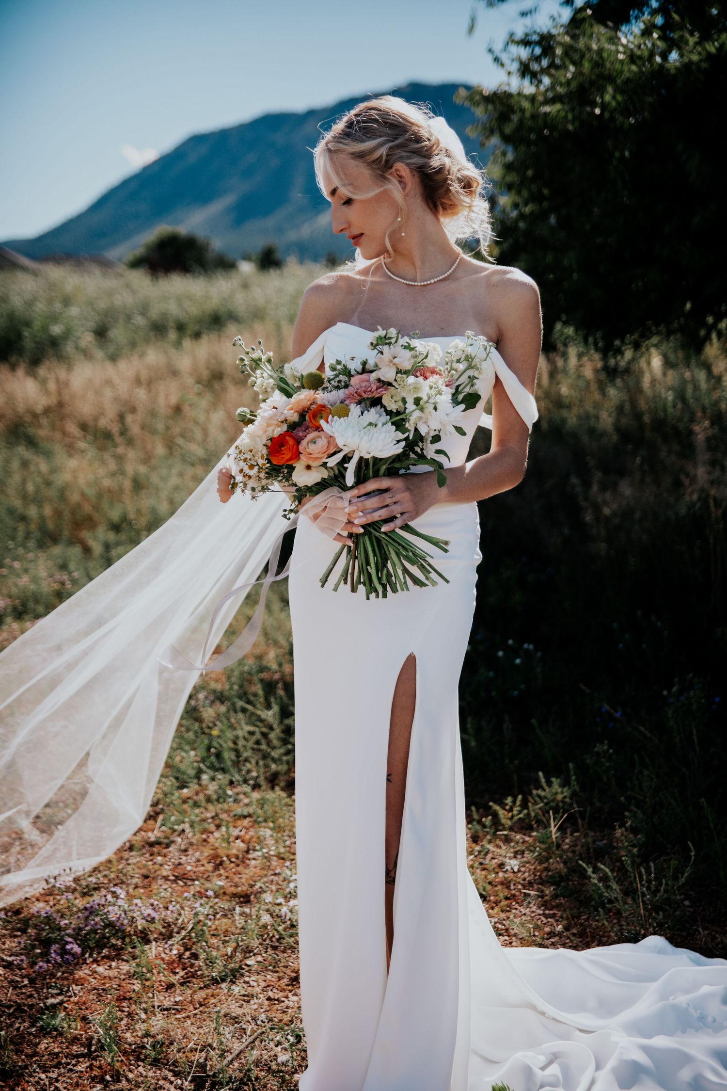 Bride with wildflower bouquet in front of Colorado foothills during Palmer Lake wedding near Colorado Springs