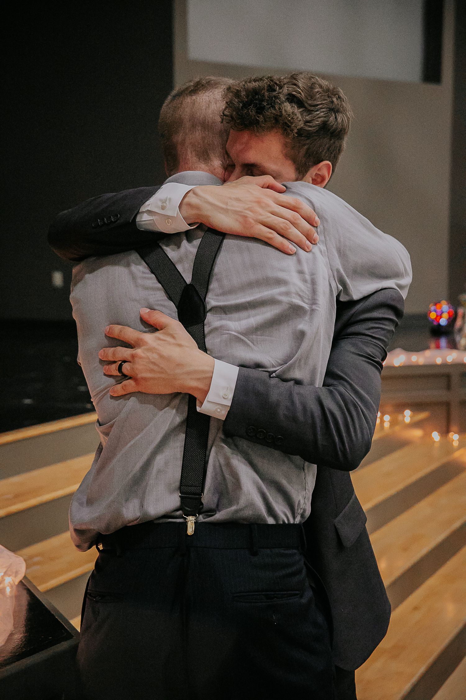 An emotional embrace shared between two people at a wedding reception.