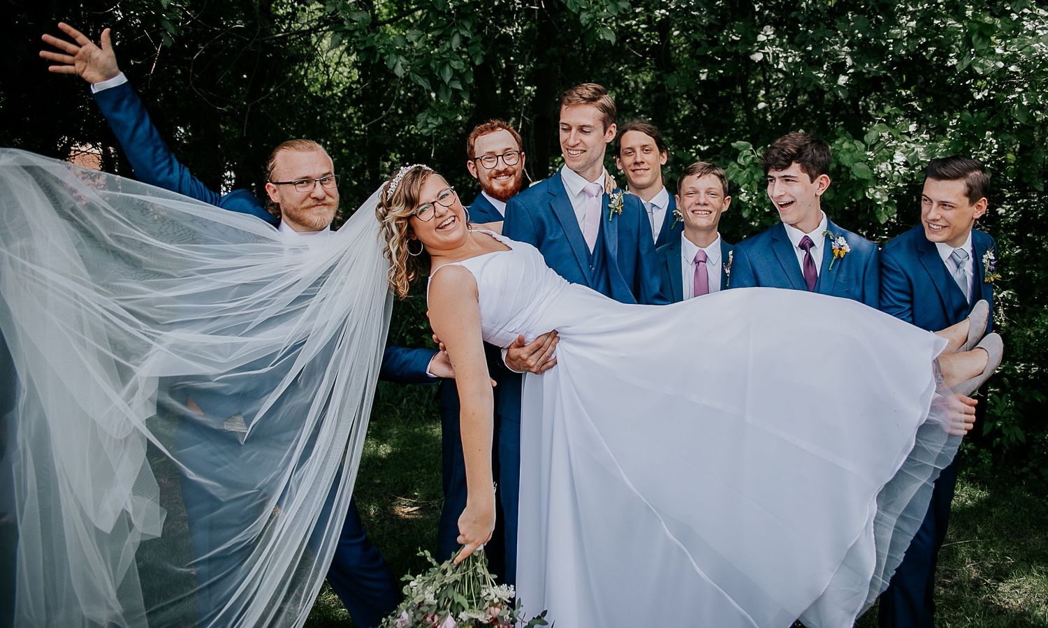 Indoor wedding ceremony with bride and groom at altar with white draping and wooden cross.