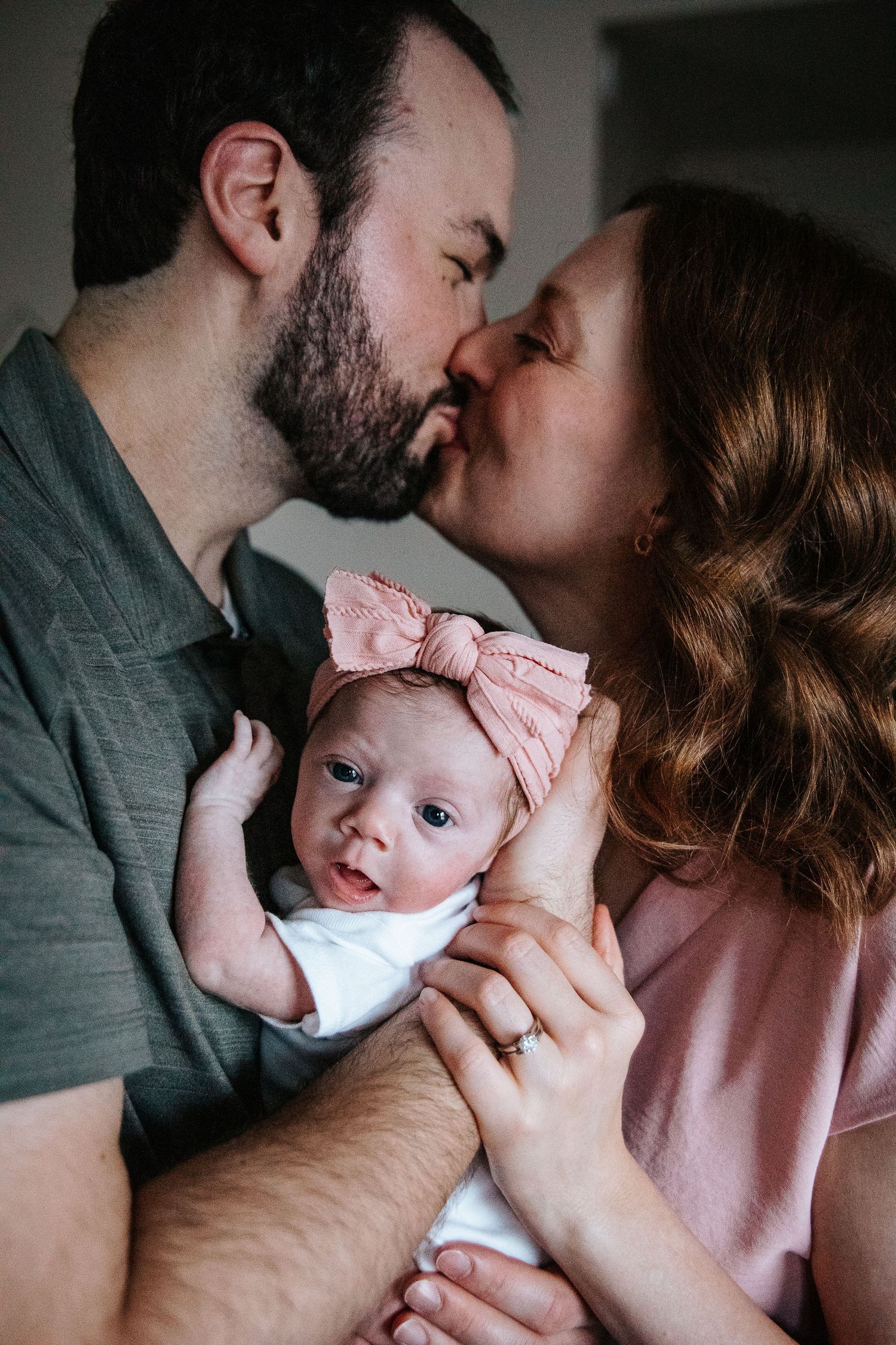 A loving couple shares tender moments with their baby in a series of intimate black and white photographs.