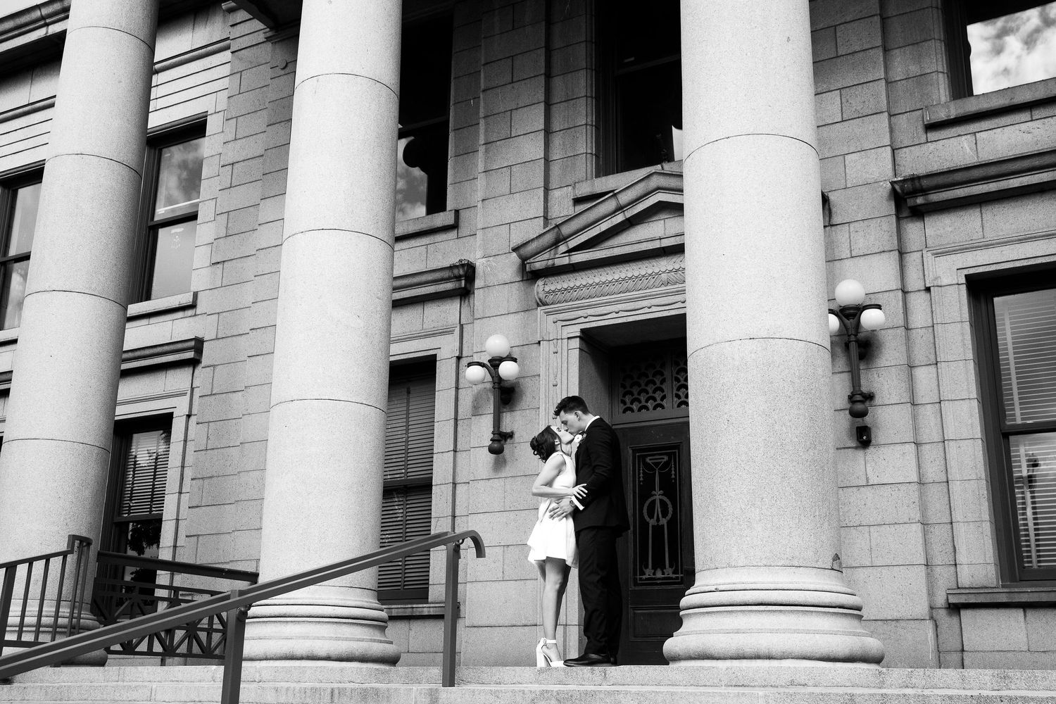 Neoclassical courthouse building exterior with tall white columns and stone facade in black and white.