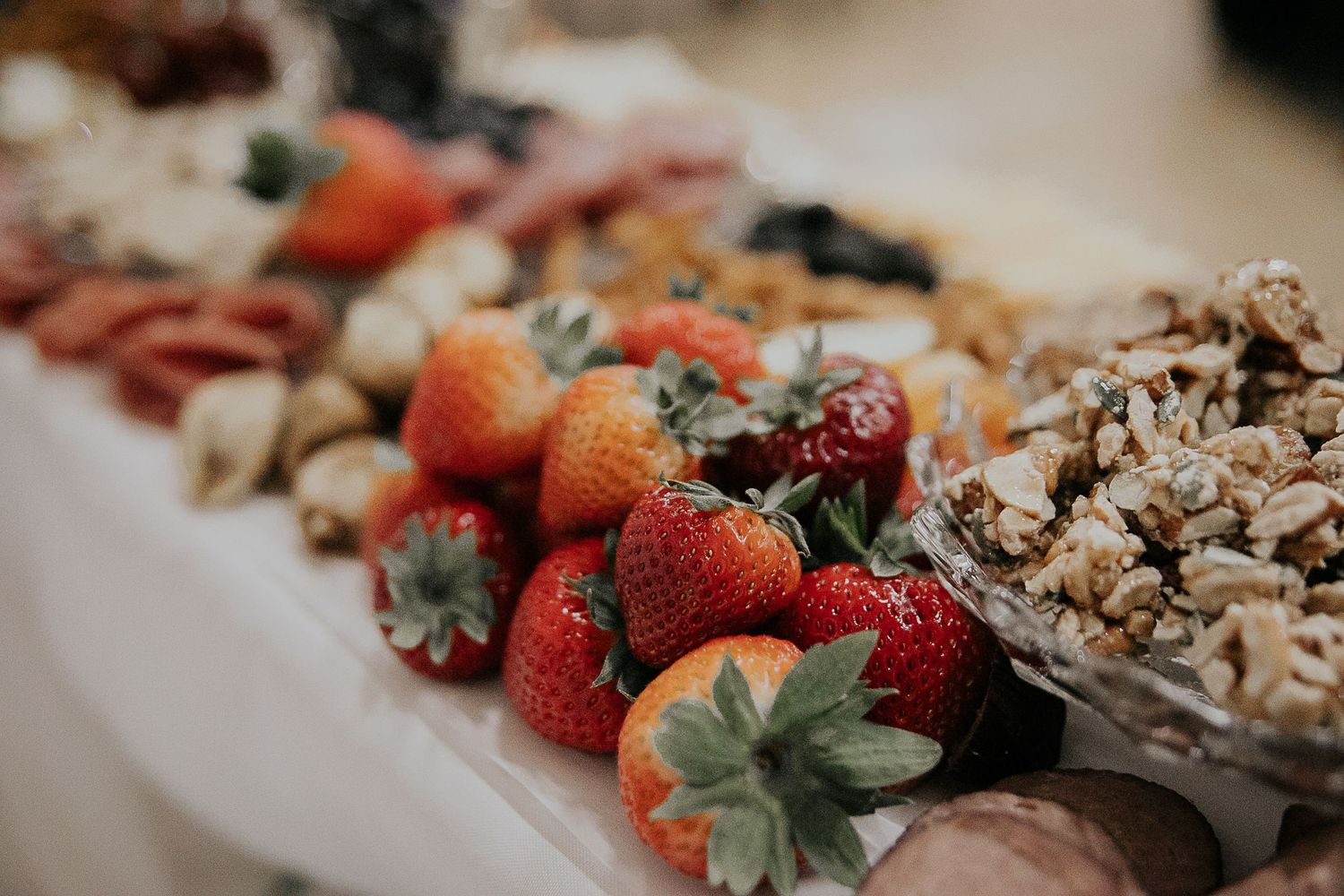 Fresh strawberries and assorted desserts displayed on an elegant wedding reception table.