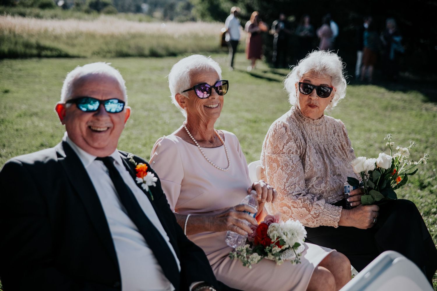 Wedding guests enjoying a sunny outdoor garden reception.