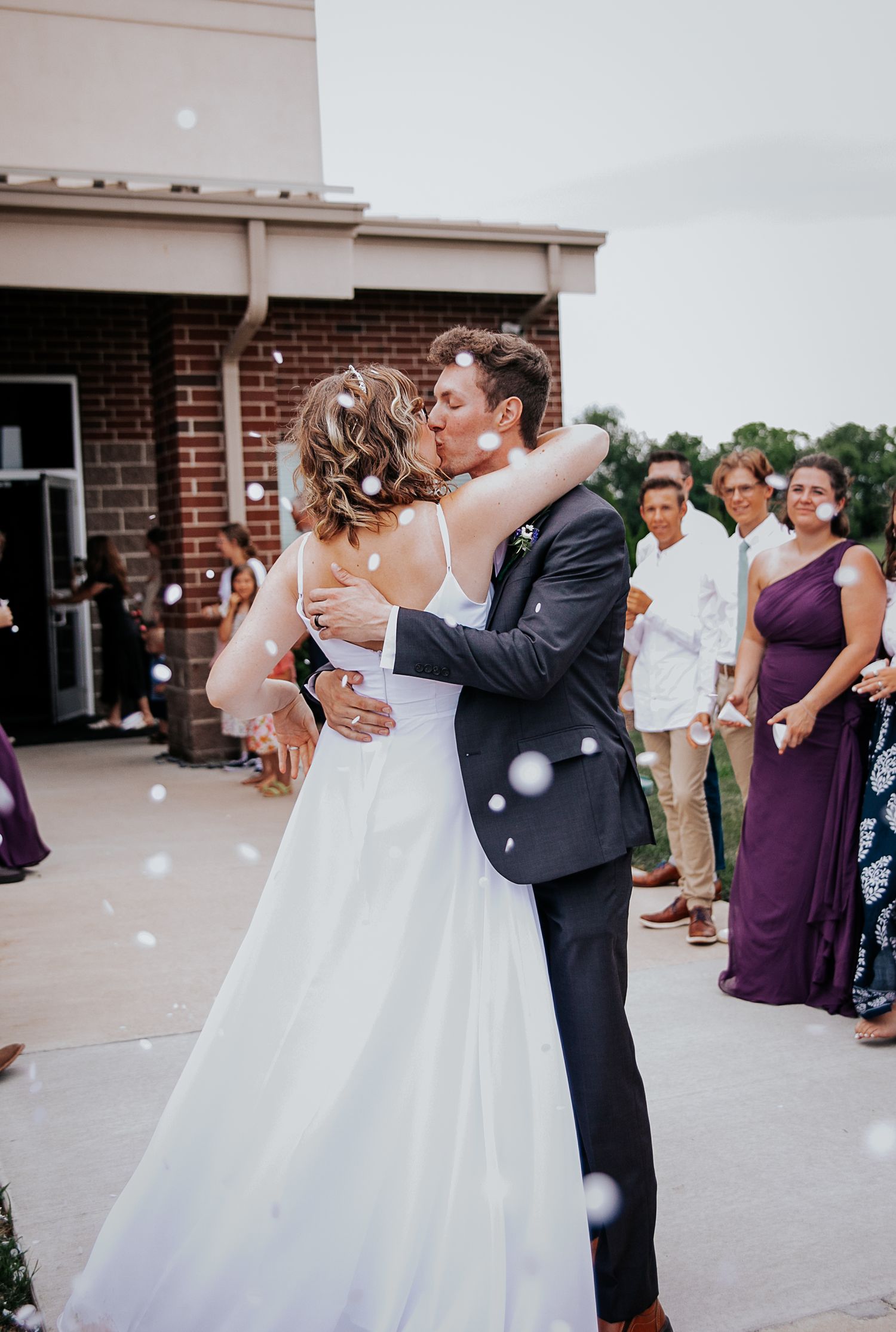 A couple shares their first dance as newlyweds surrounded by wedding guests.
