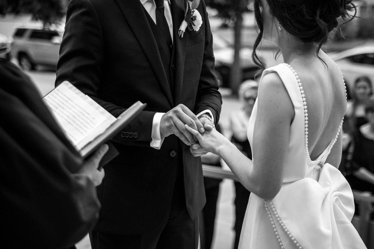 Outdoor wedding ceremony with couple exchanging vows surrounded by guests.