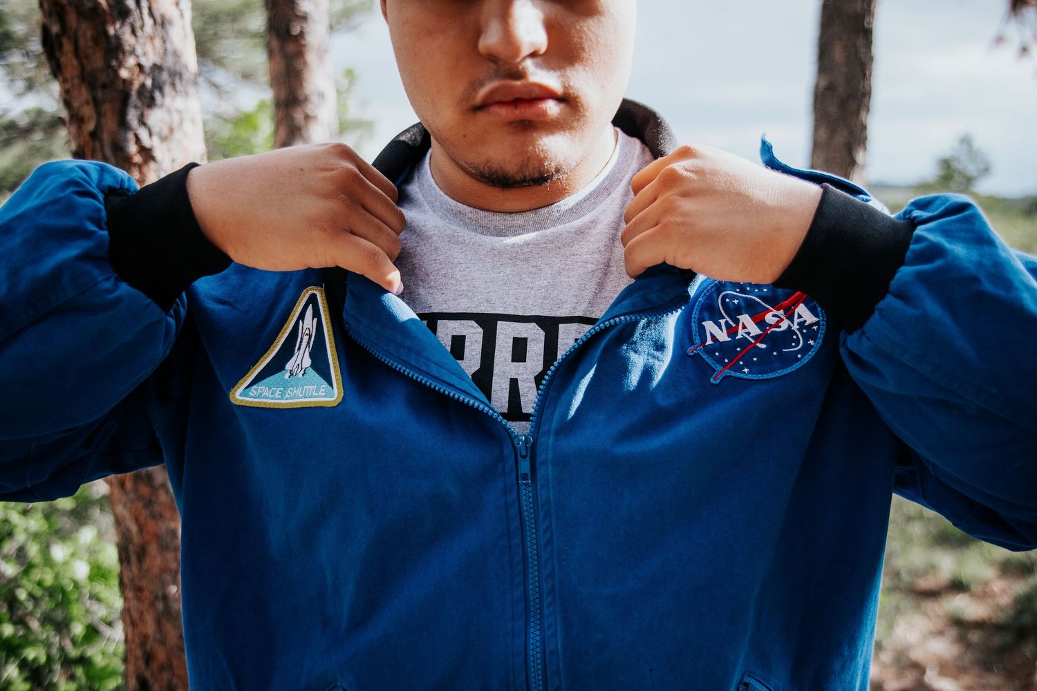 Close-up shot of NASA jacket with space mission patches and embroidered details.