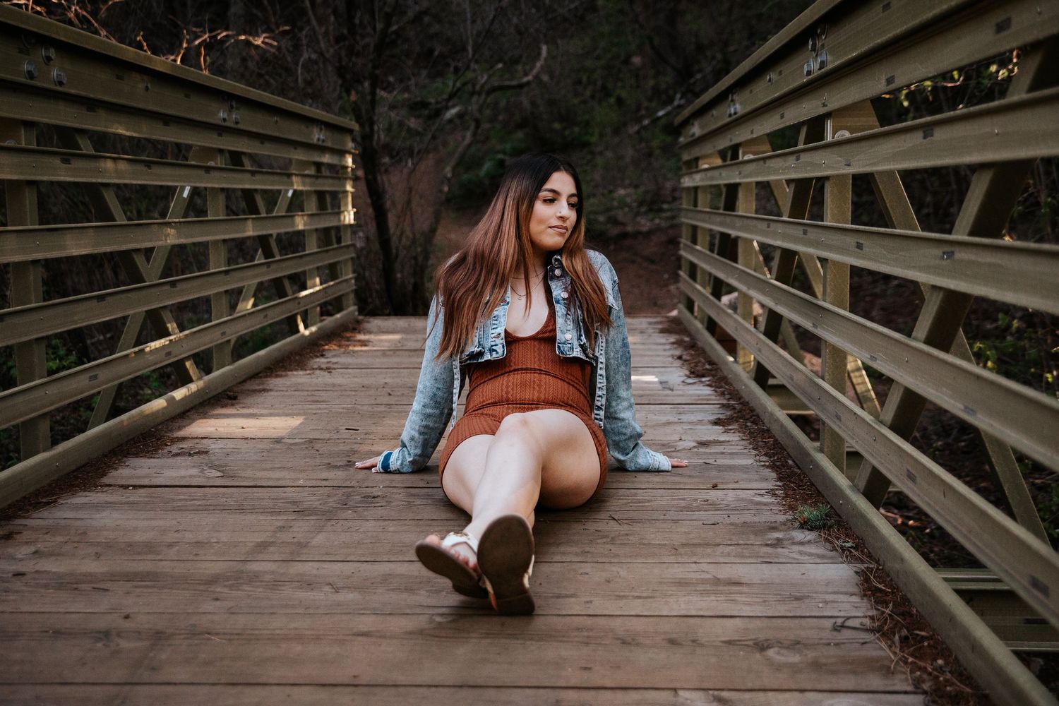 Portrait on wooden boardwalk bridge with natural lighting and casual denim outfit at North Cheyenne Canon in Colorado Springs