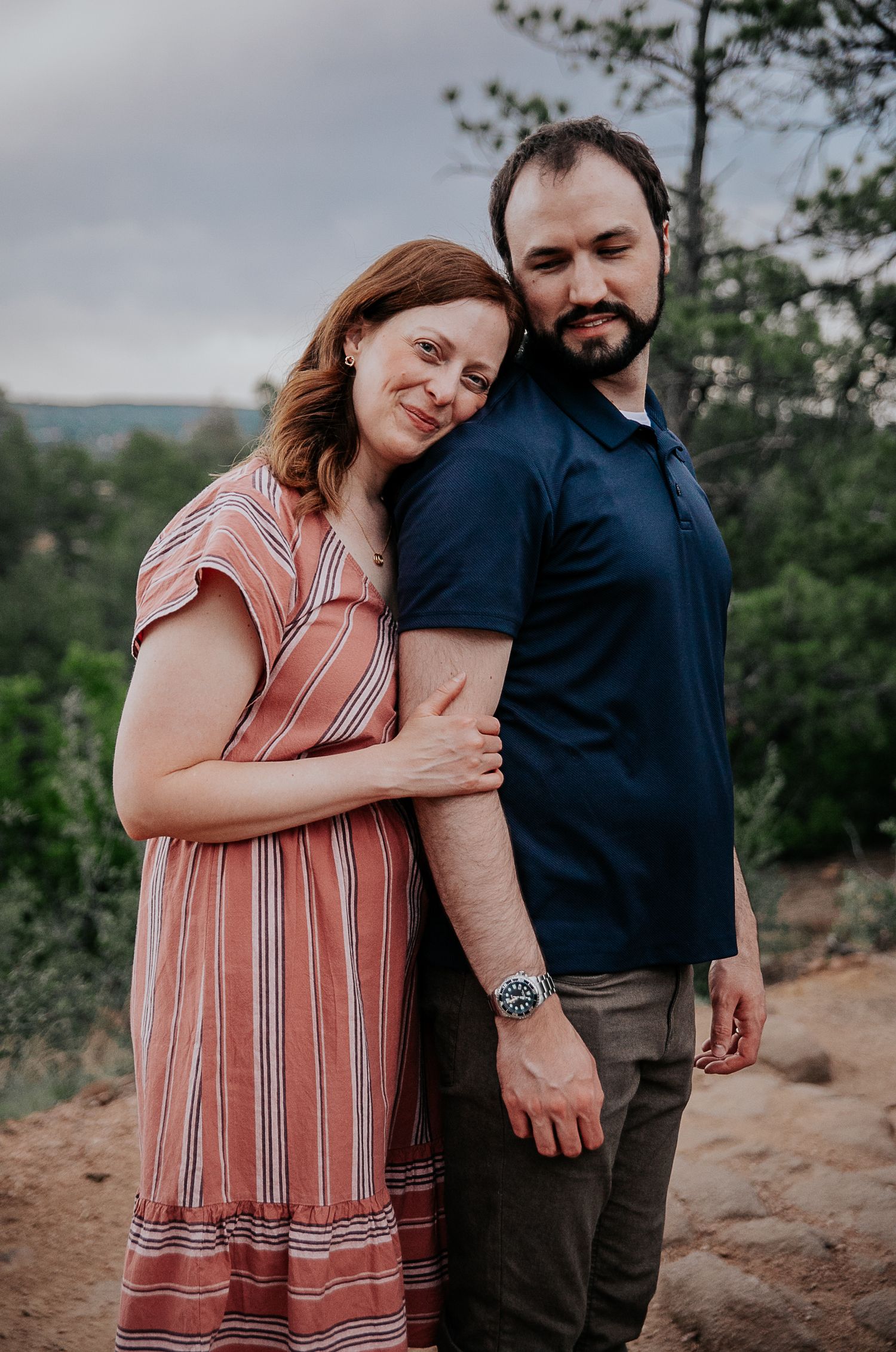 A tender moment captured between a couple on a rocky outdoor setting.