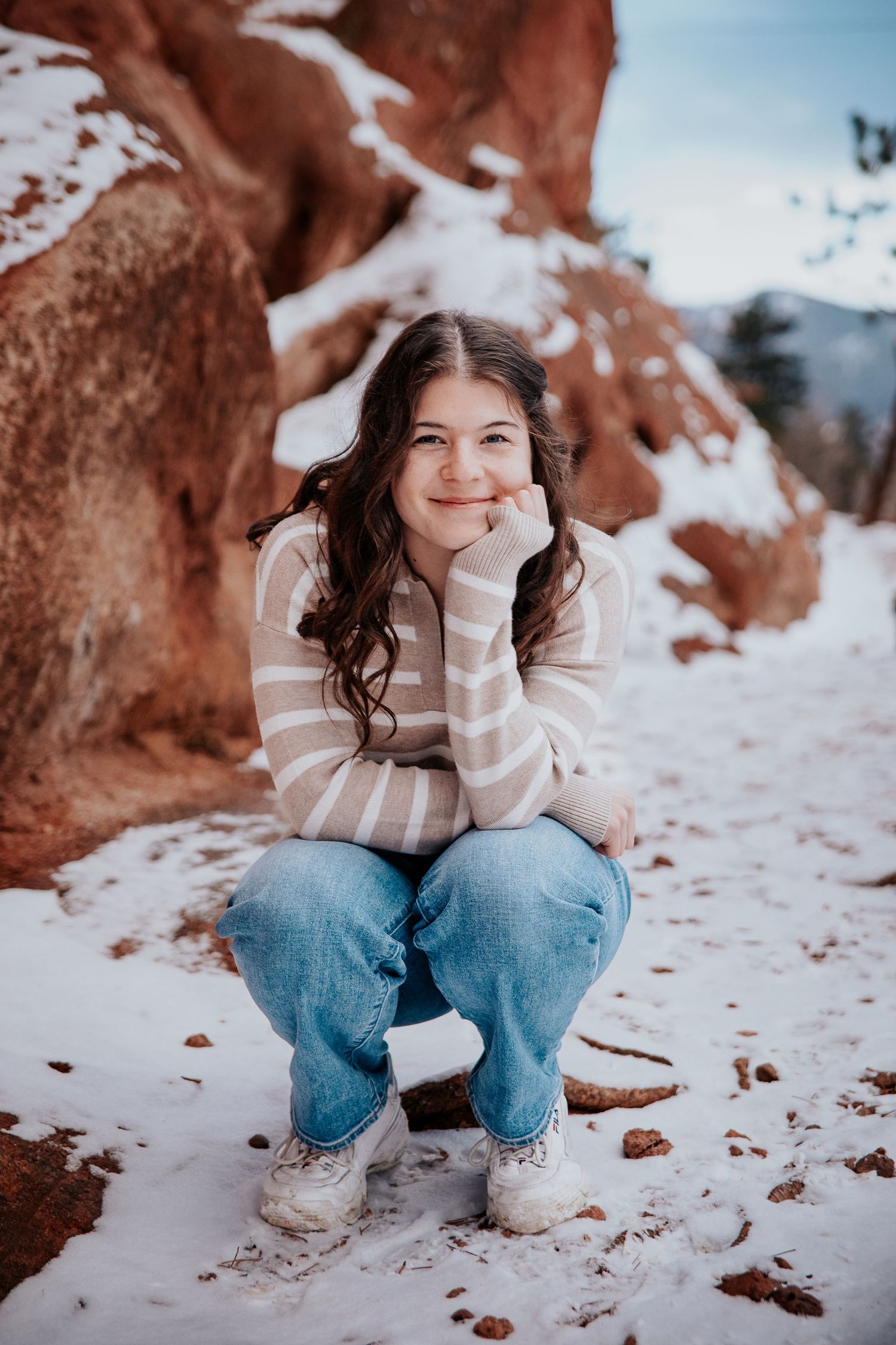 Winter photography session with snowy ground and red rock formations in the background.