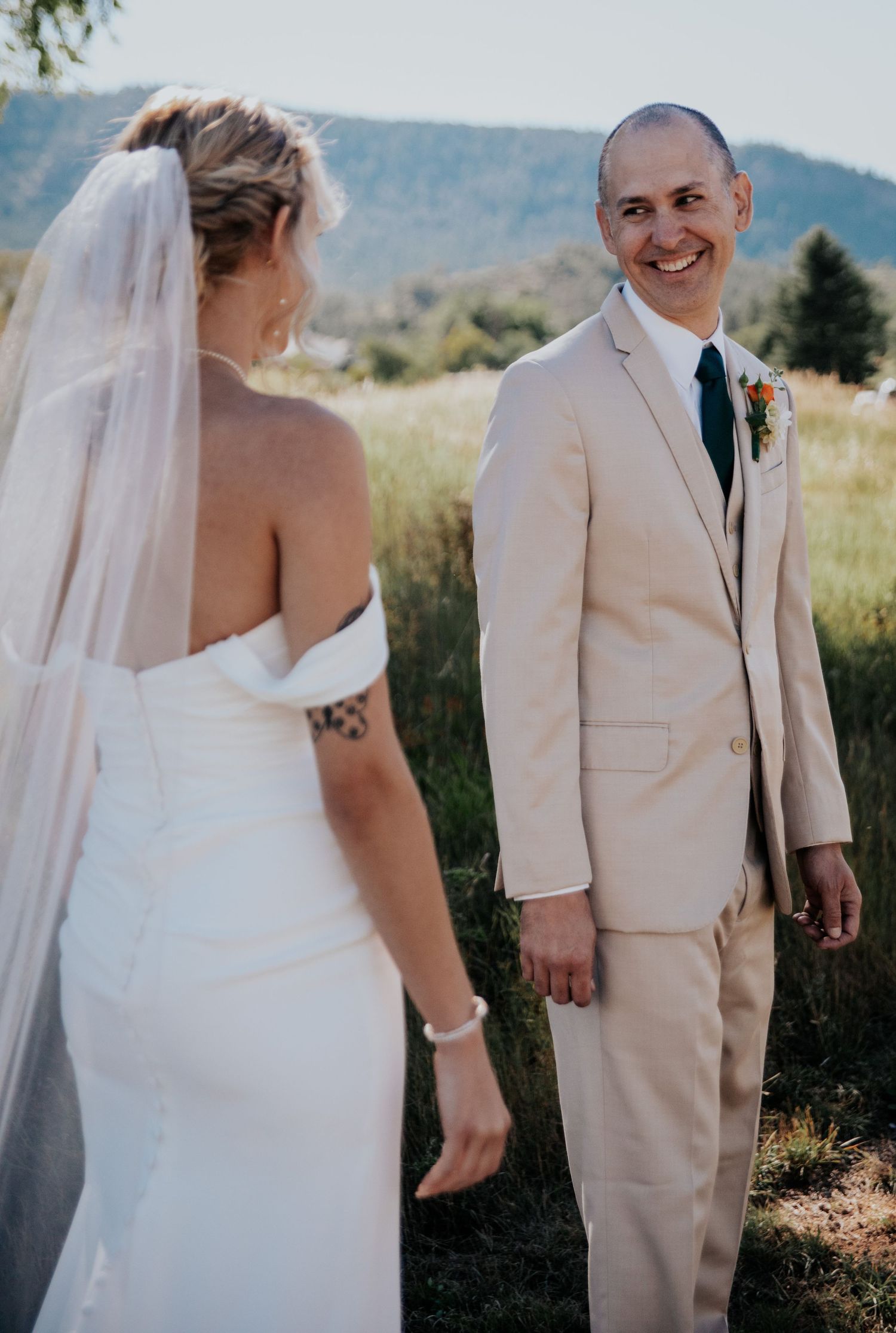 A candid wedding moment photographed in a scenic mountain setting.