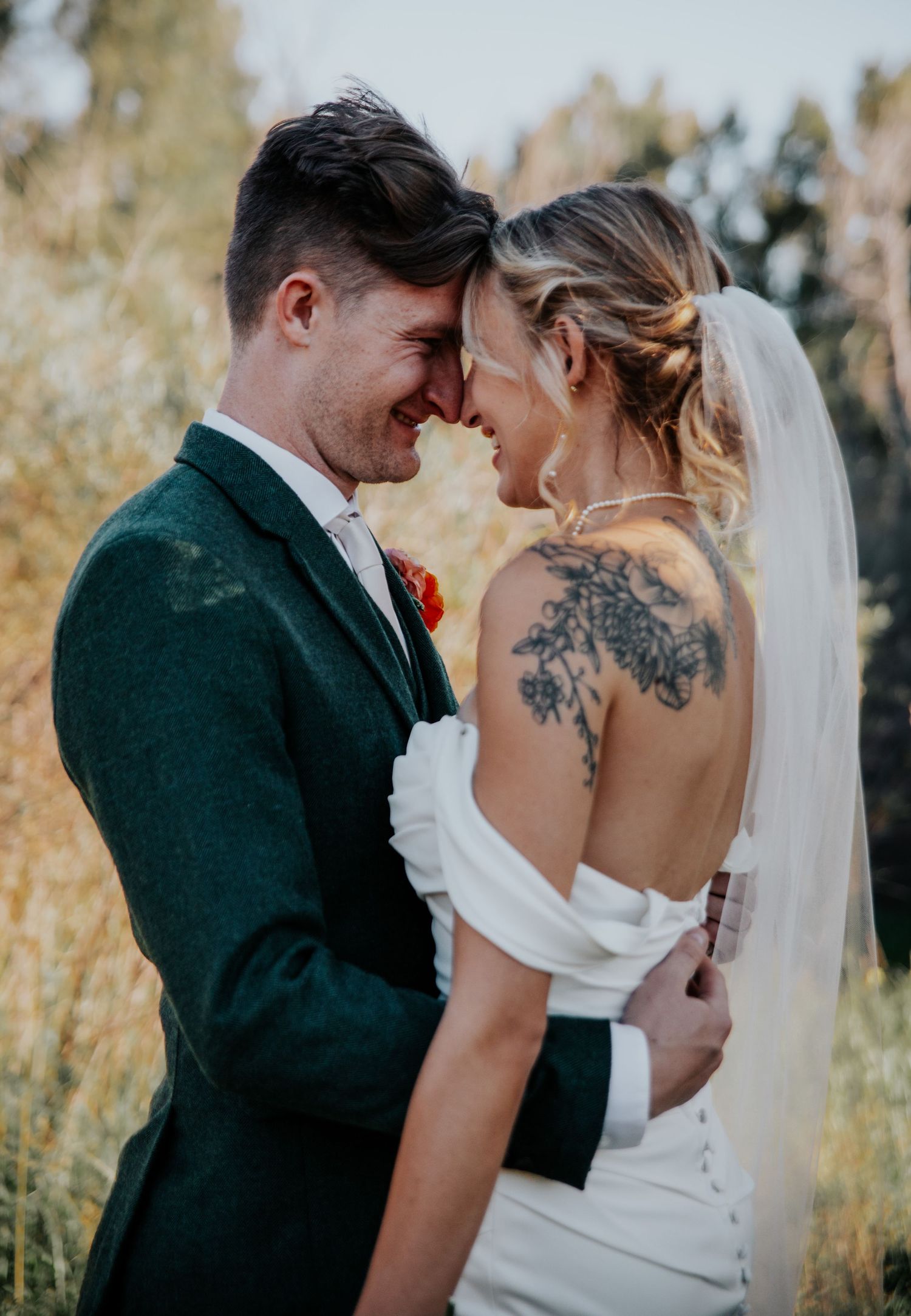 Intimate wedding portraits showing couple in formal attire against autumn backdrop.