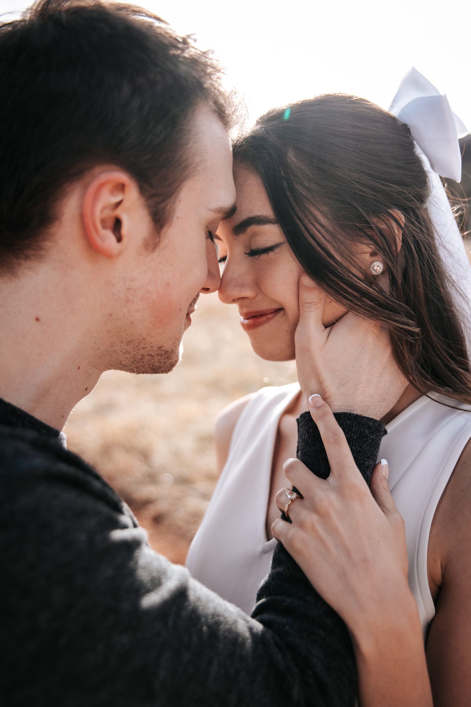 A romantic couple shares an intimate moment outdoors with soft lighting.
