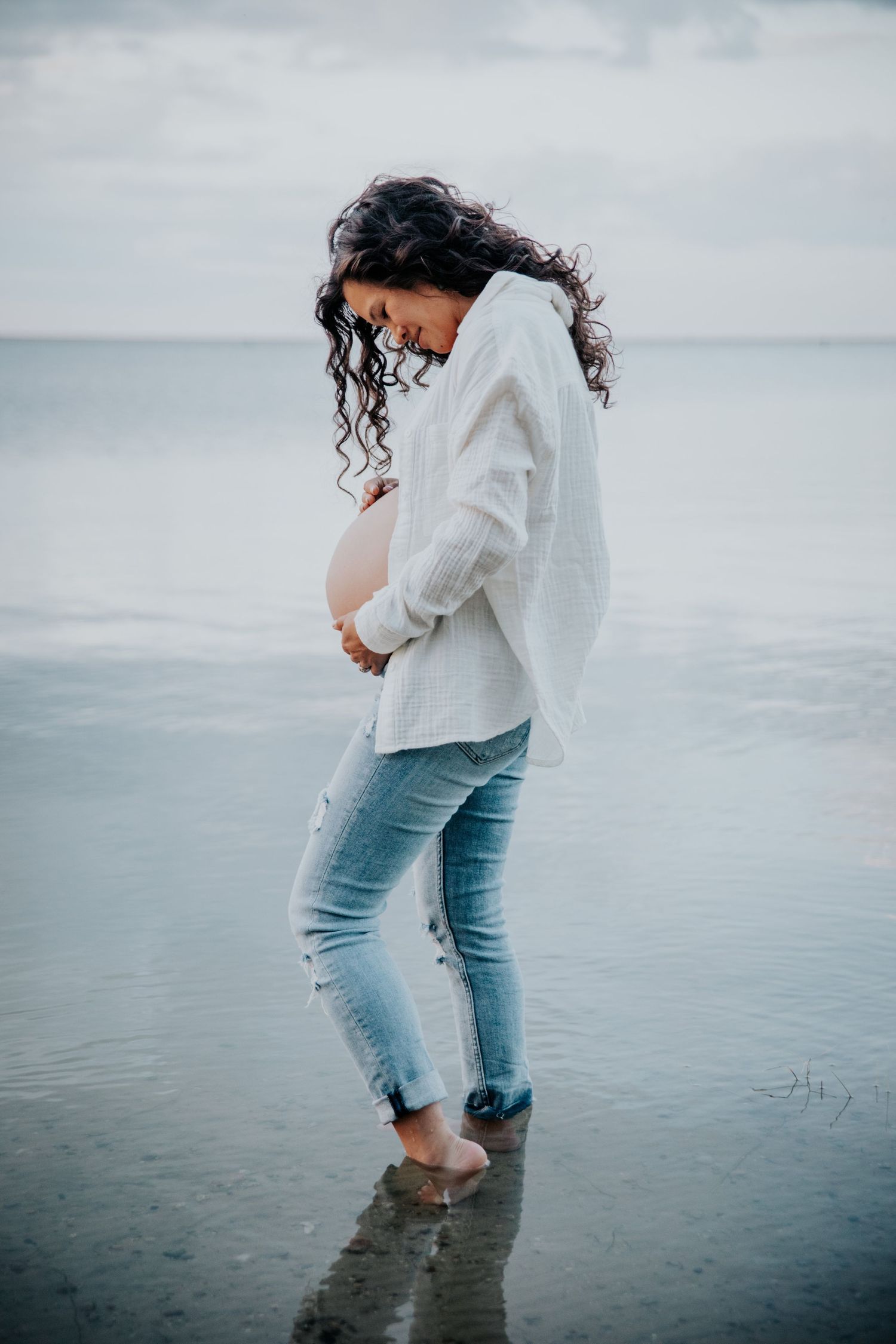 Pregnant woman holding belly during maternity photo session in Colorado Springs