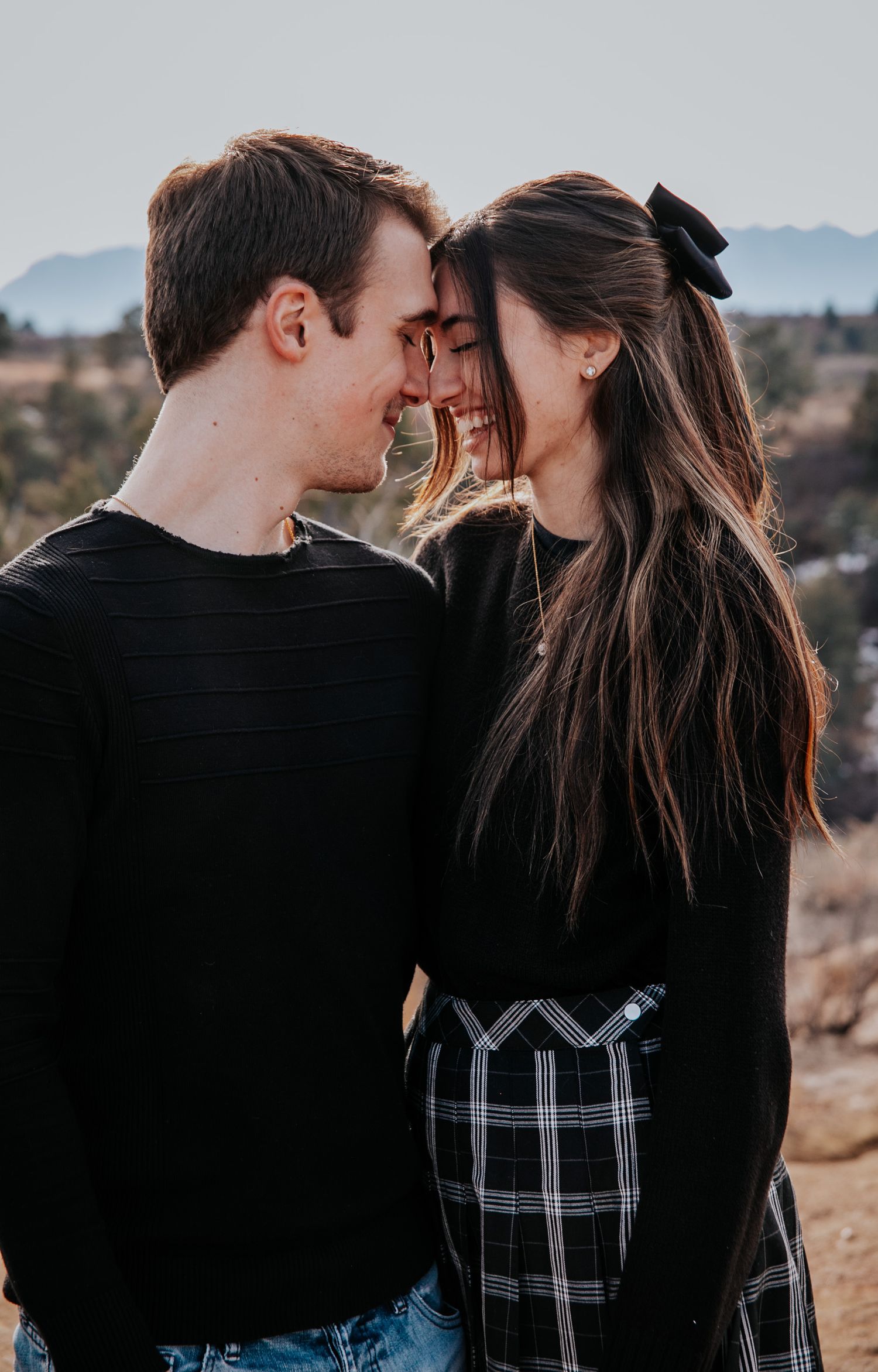 Intimate black and white portrait series of a couple sharing tender moments outdoors.